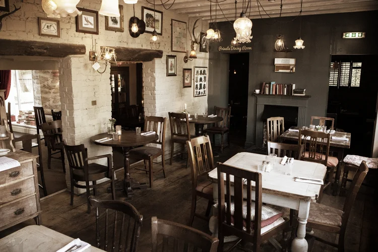 Tables laid in the dining room under pendant lights