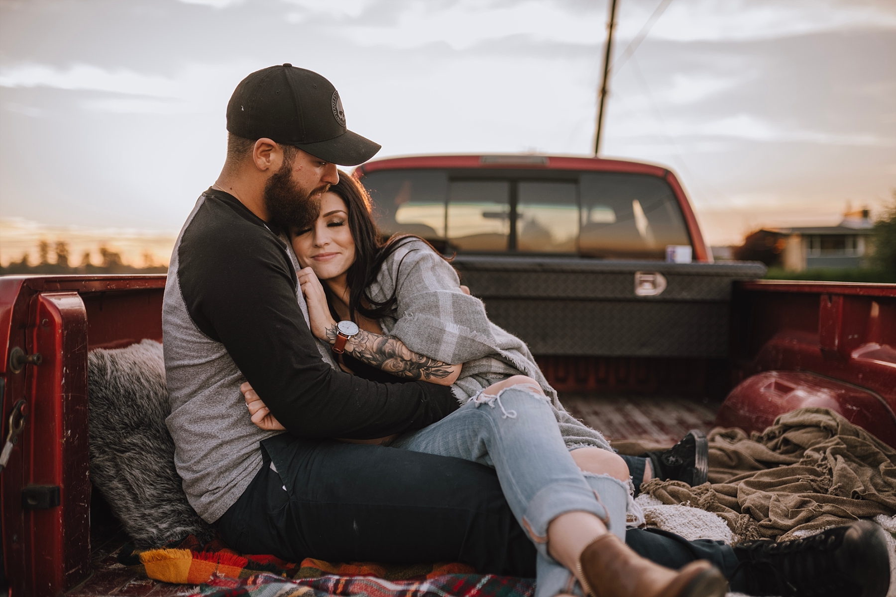 couple cuddling in the back of a truck