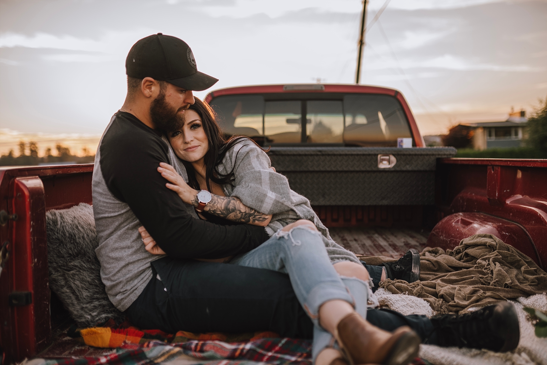 couple cuddling in the back of a truck
