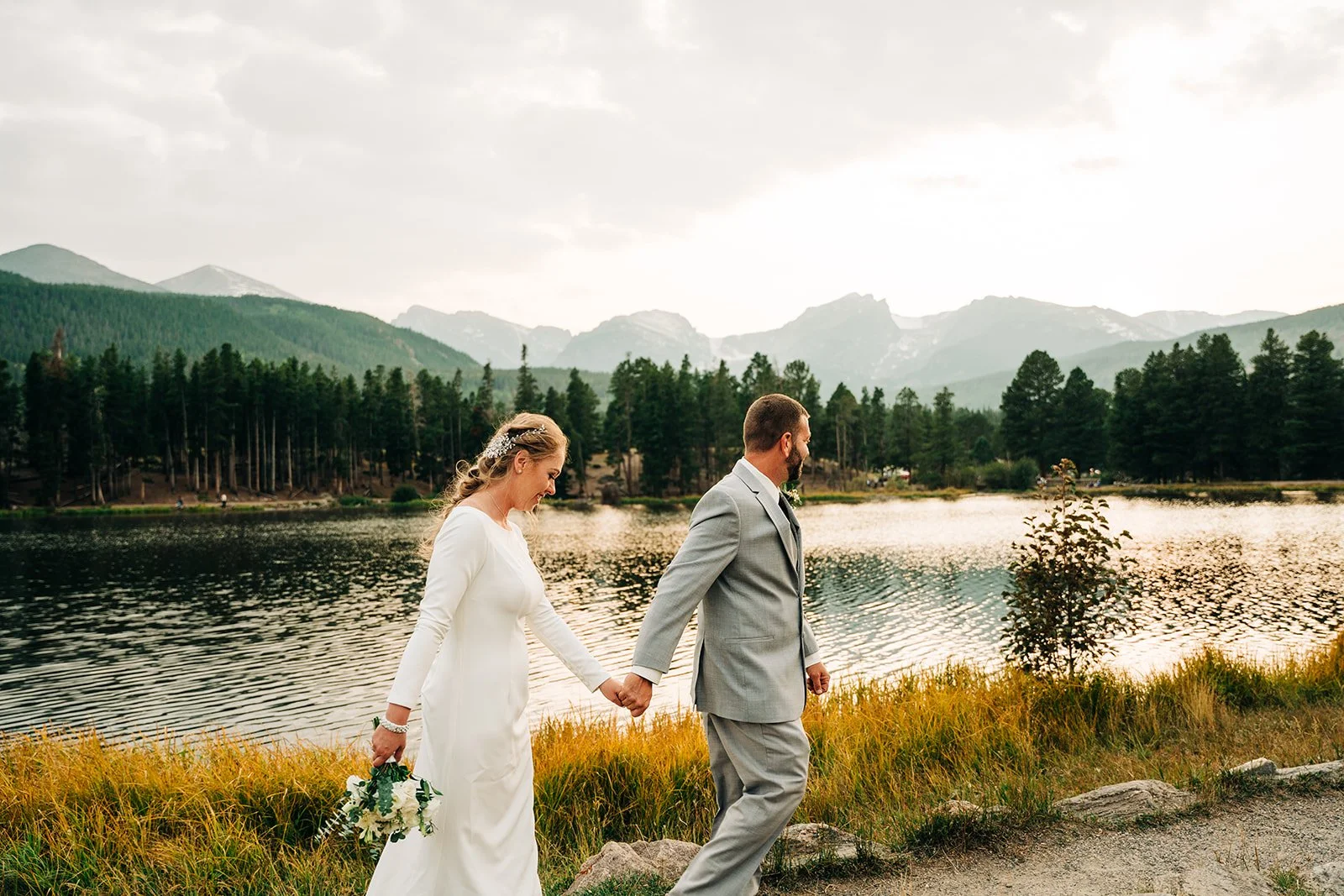 couple walking along a lake for an elopeemnt in rocky mountain national park