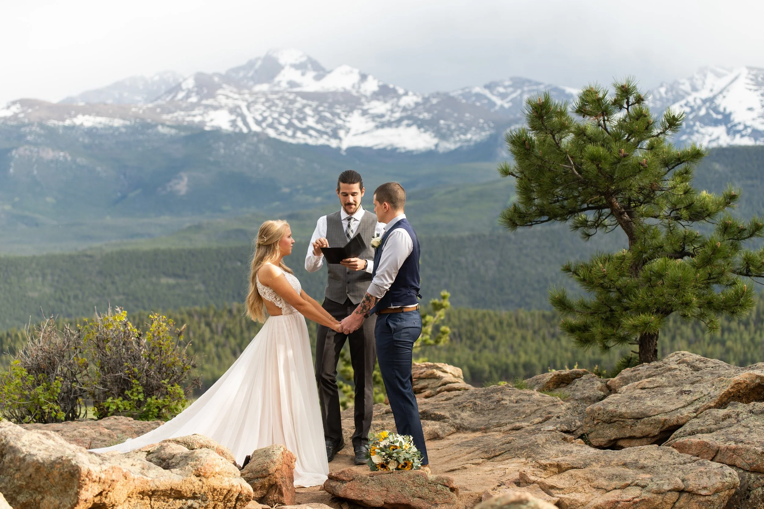 rocky mountain national park elopement with bride and groom exchanging vows at sunset