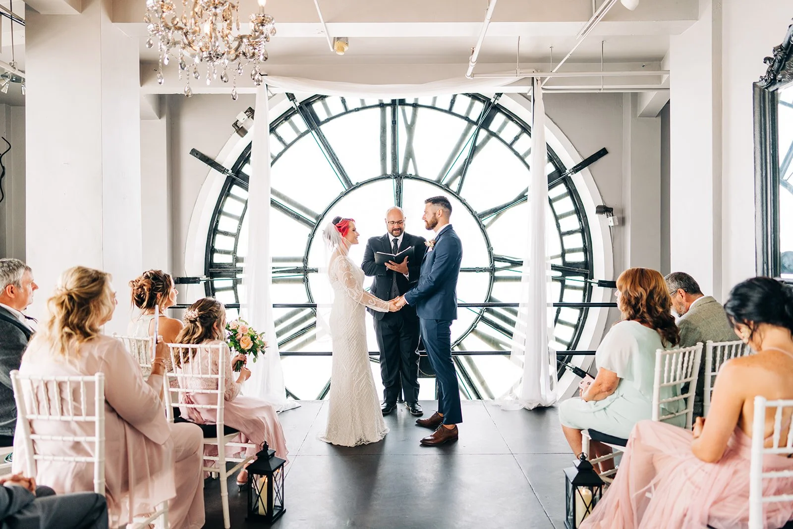 small wedding elopement in the clock tower in downtown denver, with the couple standing behind the clock face for the ceremony.