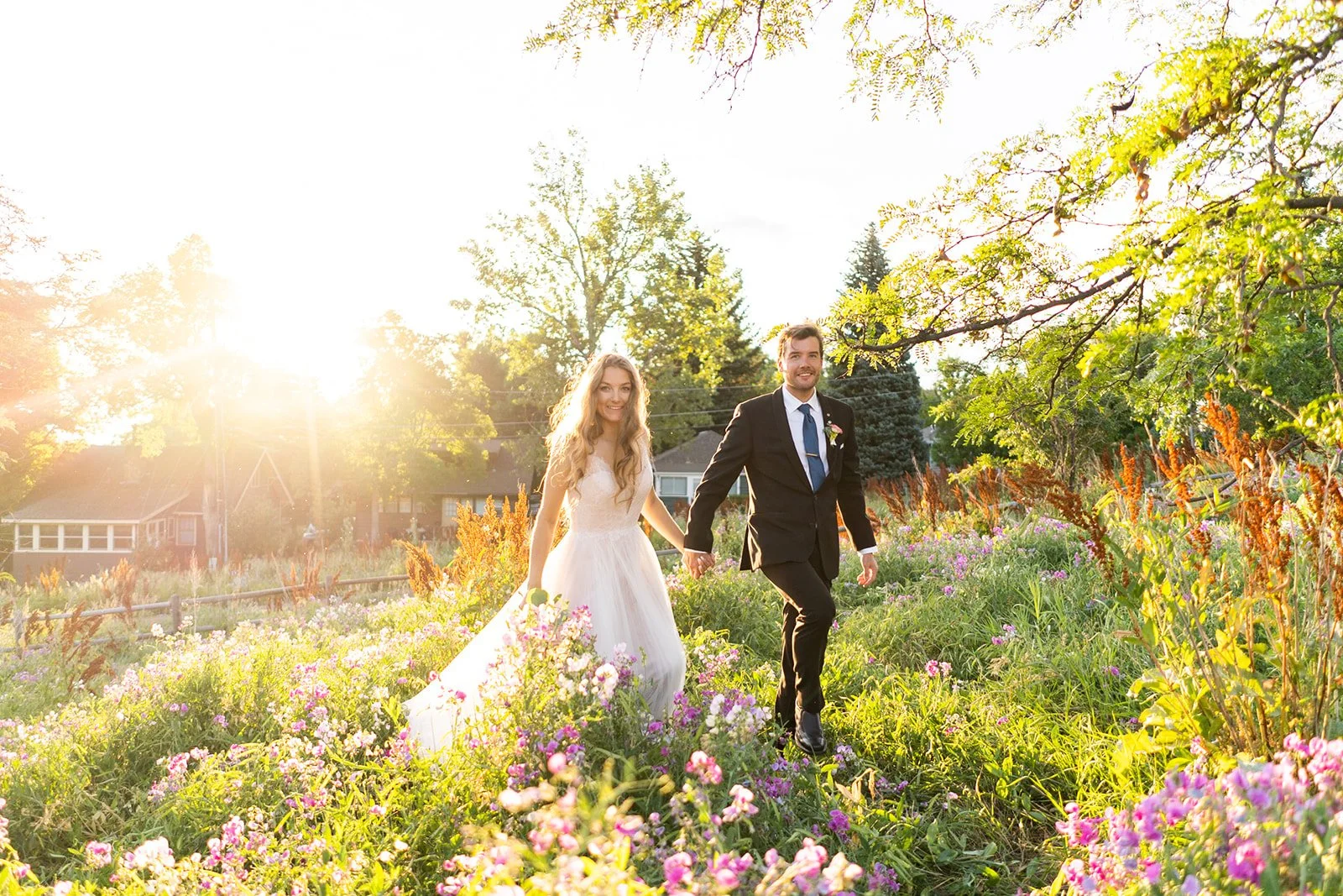 bride and groom running through flower garden after their elopement in colorado