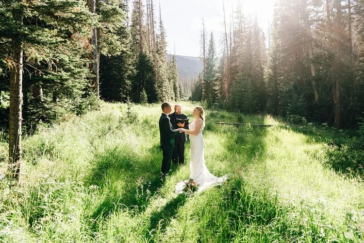 rocky mountain national park hidden valley wedding ceremony site with bride and groom exchanging vows at sunrise, evergreen forest in background