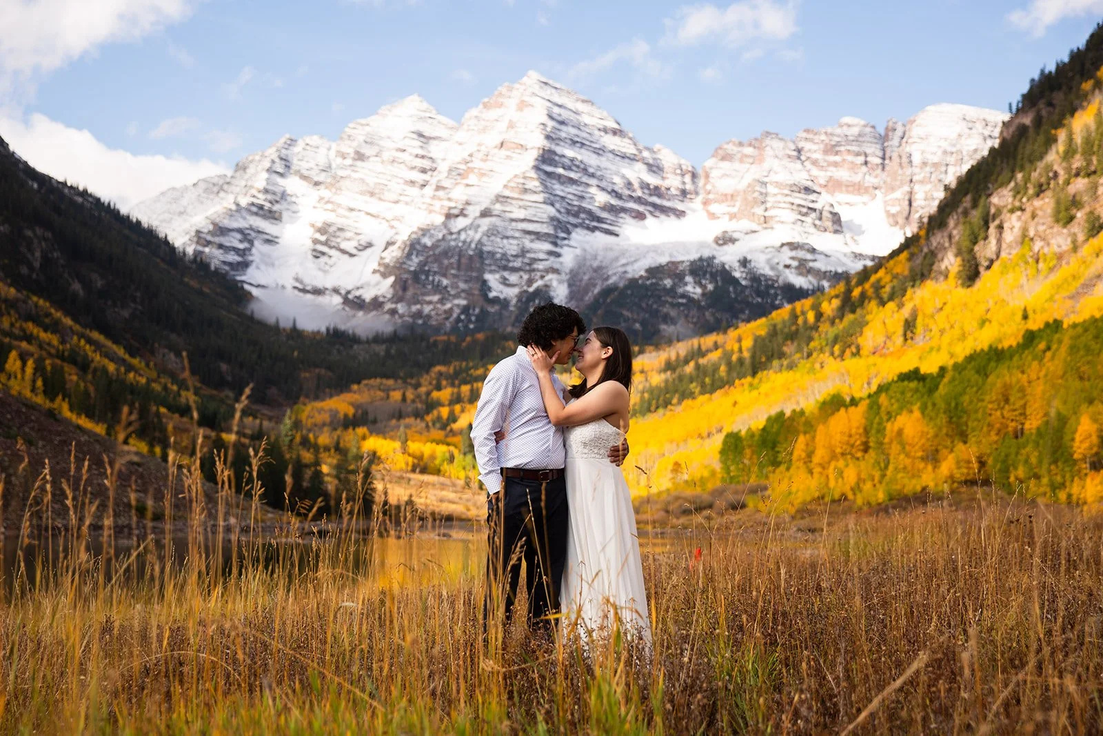 wedding at maroon bells with fall colors and snow on the mountain, couple embracing