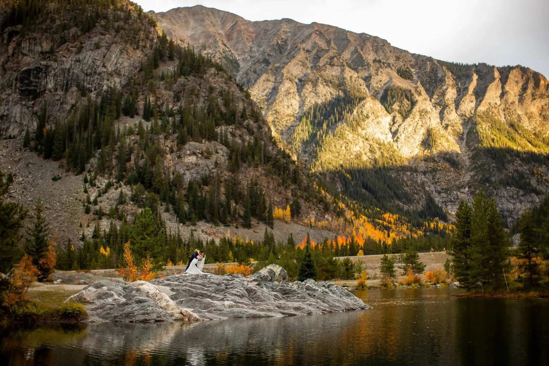 bride and groom taking portraits after their elopement wedding at Officers Gulch near Frisco, Colorado