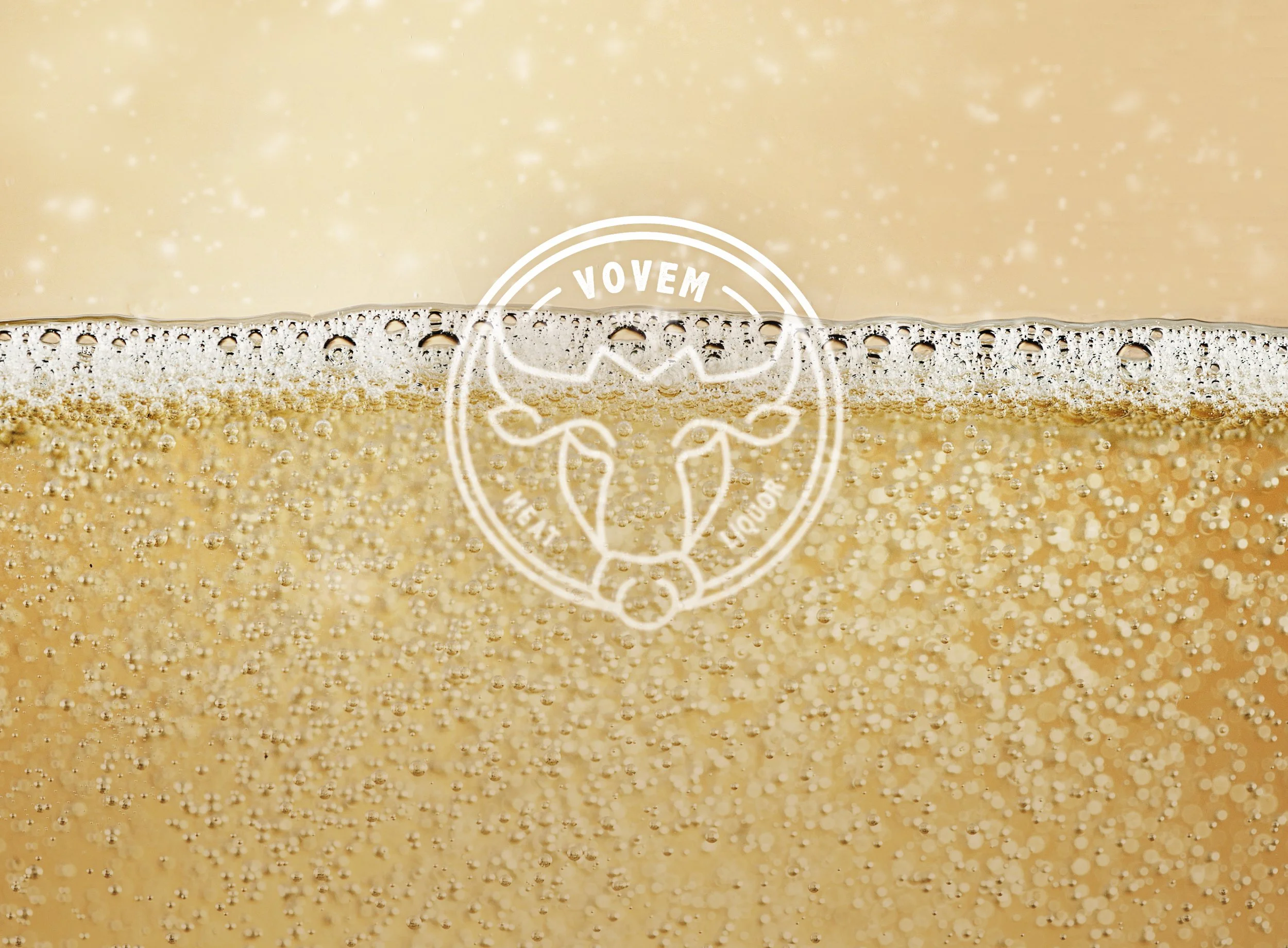 Close up of sparkling wine showing the bubbles and layer of bubbles at the top of the drink, with Vovem logo overlaid