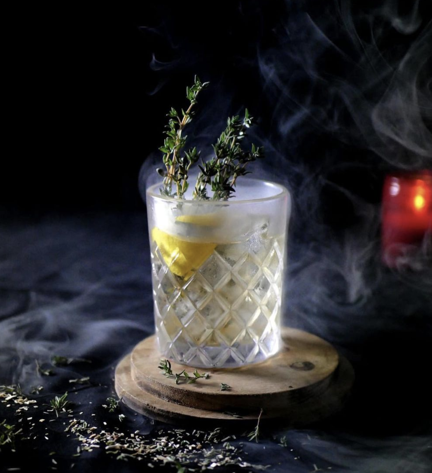 Image of cocktail in crystal glass in 21 Crimes bar, garnished with lemon and rosemary