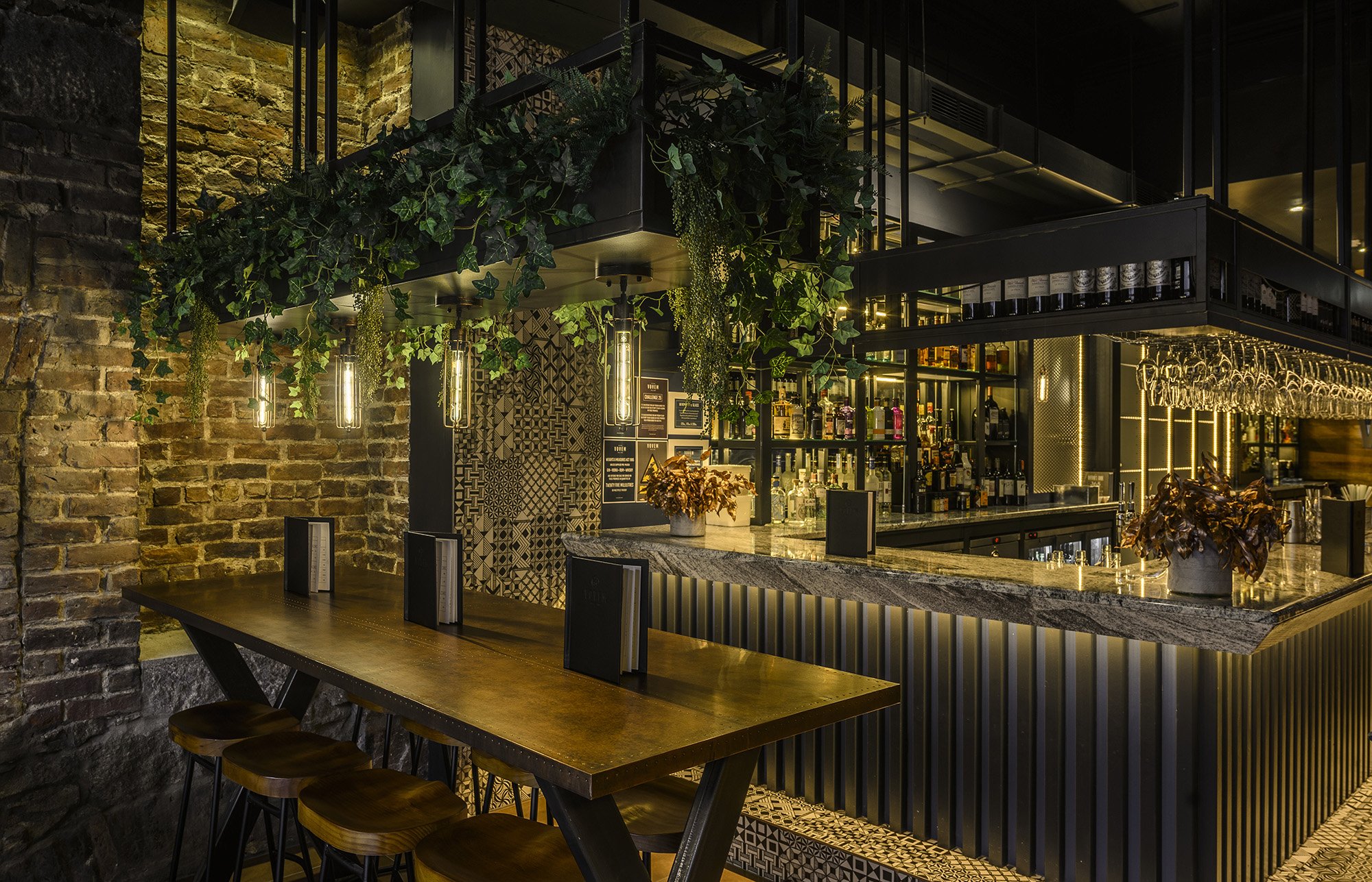 Image of high tables and stool seating and the bar in the Vovem Bar