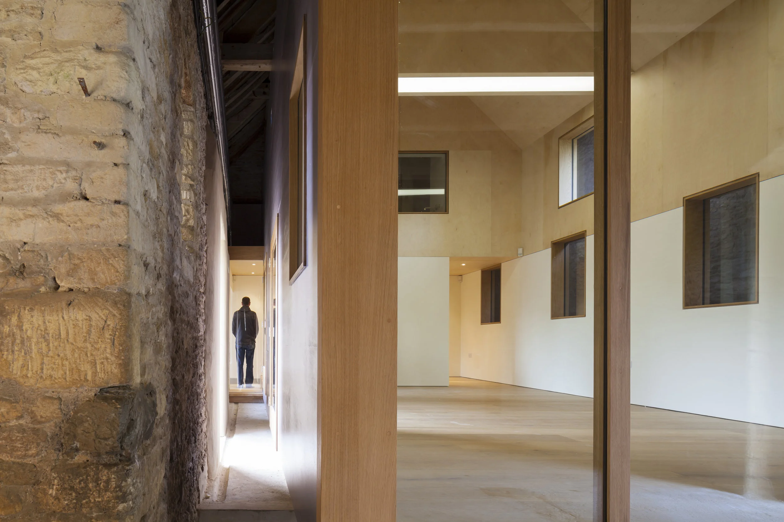 The soft warm qualities of the timber Gallery contrast with the hard cold structure of the stone Barn.
