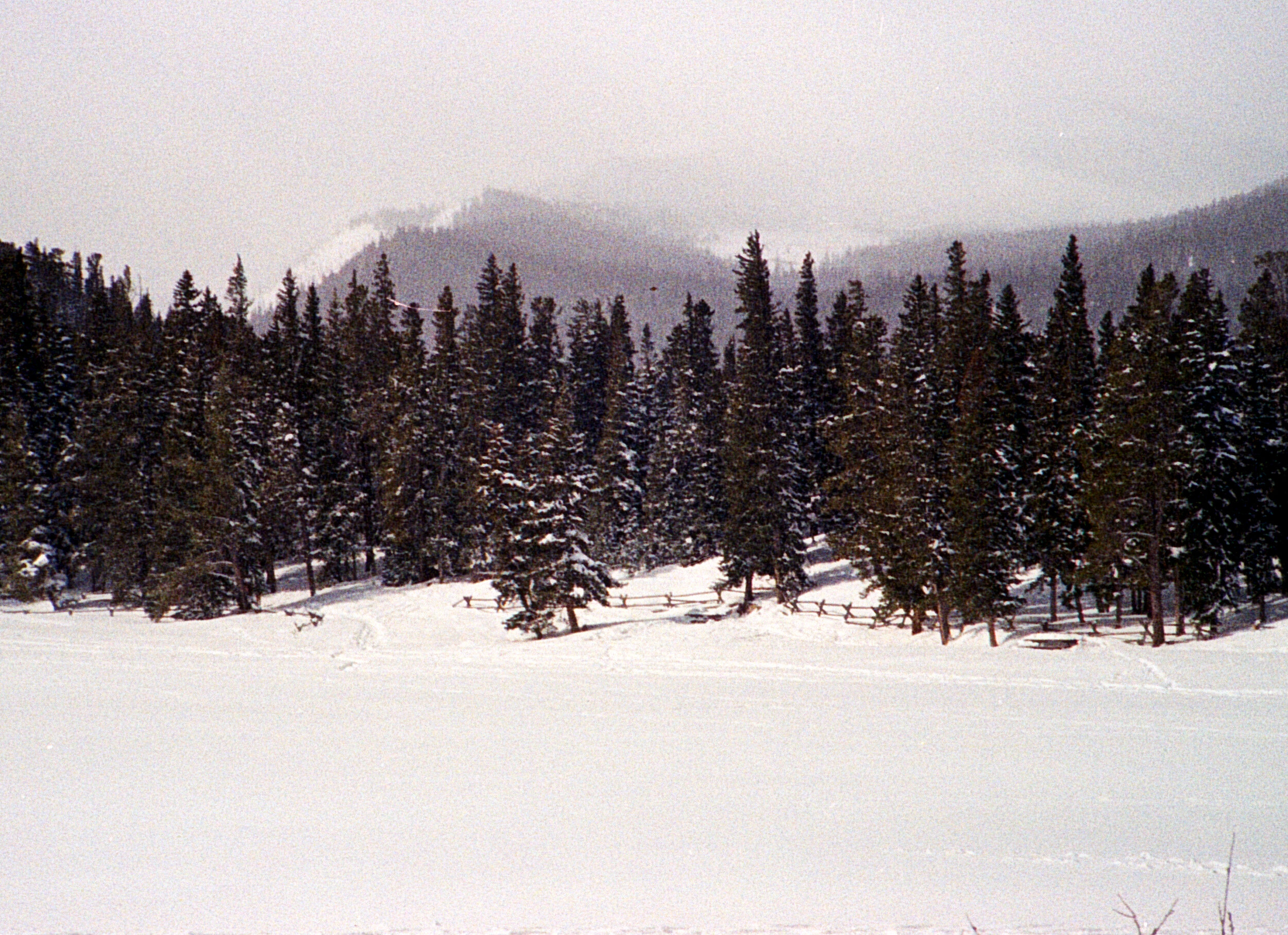 Frozen lake at the base of a fog surrounded mountain peak