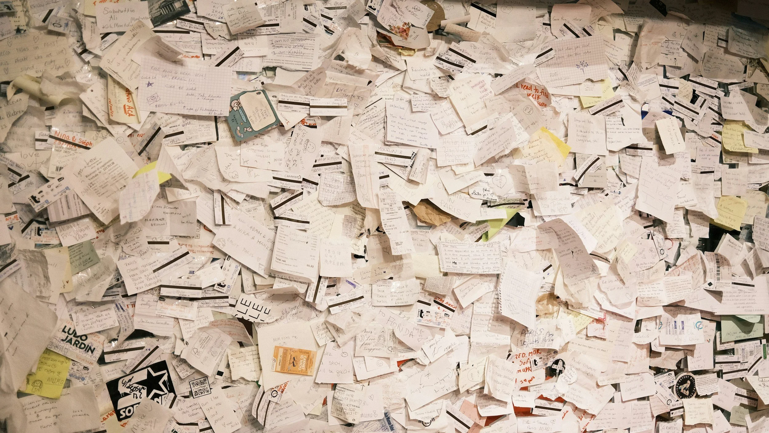 Wall covered with scattered notes, symbolising confusion, misalignment and the communication challenges organisations often face