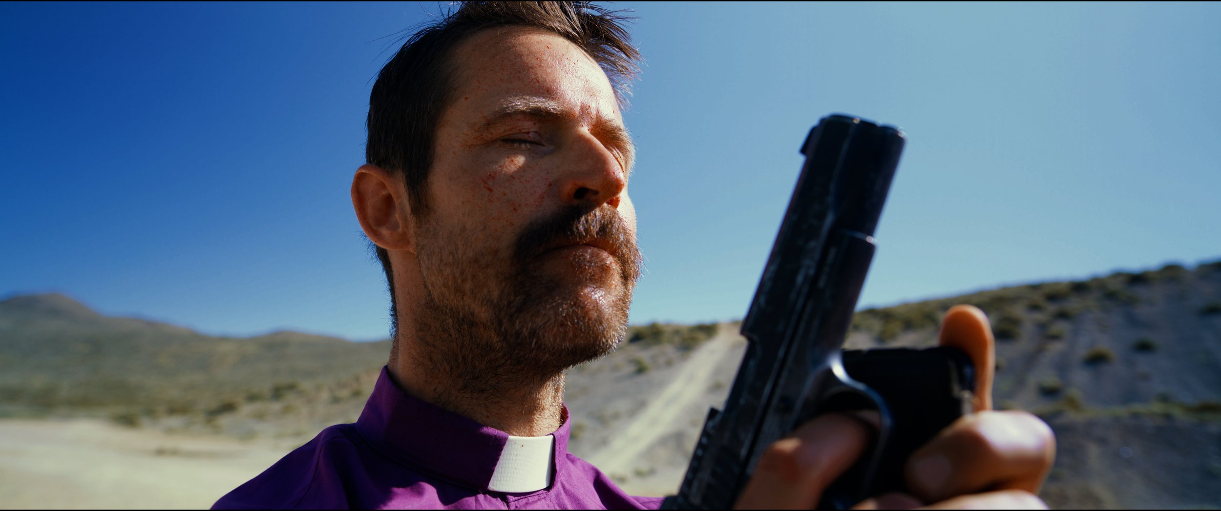 Chad_Michael_Father_Roger_CU holding gun praying blood on face.jpg