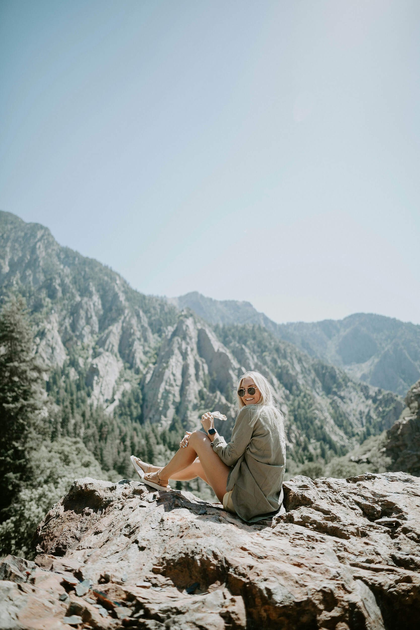 Woman sitting on rocky moutain top after holistic health services in NH