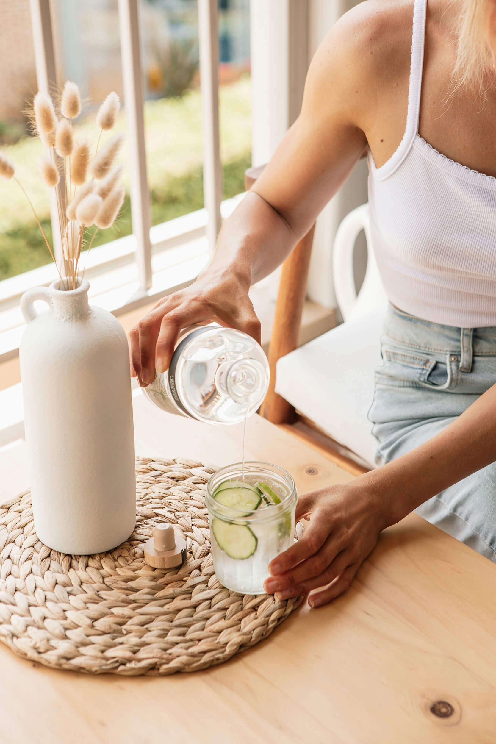 Woman making cucumber water as part of naturopathic solution for health in New Hampshire