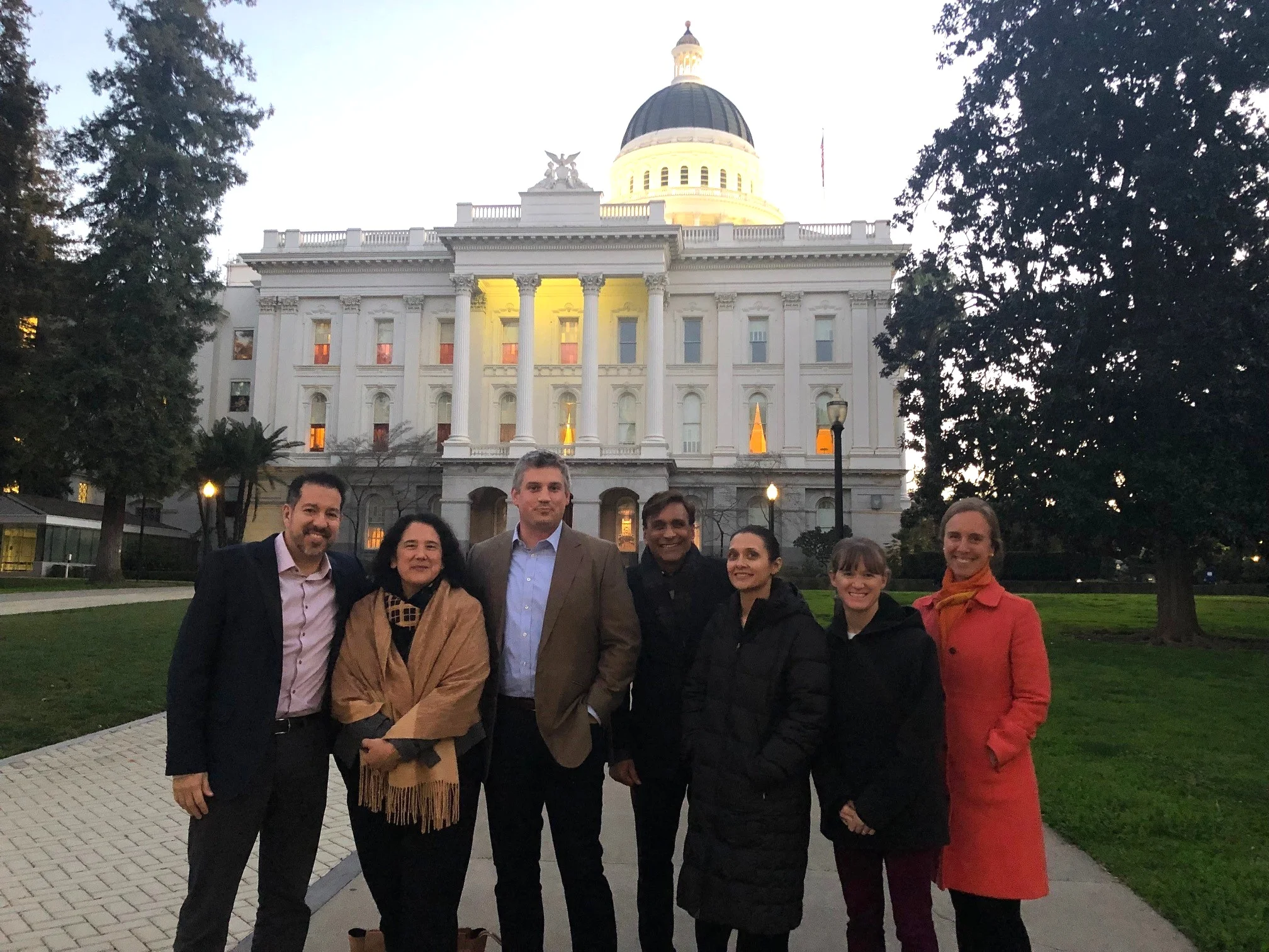 Larta’s Carlos Gutierrez (CSO), Isabel Casillas Guzman (Senior Advisor) and Rohit Shukla (CEO) accompanied by representatives from current and alumni companies Blue Forest Conservation, Mango Materials, and 7 Generation Games stand at the entrance of California’s capitol in Sacramento.
