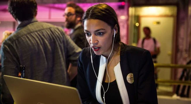AlexandriaOcasioCortezLooksAtLaptopOnMidtermPrimaryElectionNight.jpg.653x0_q80_crop-smart.jpg
