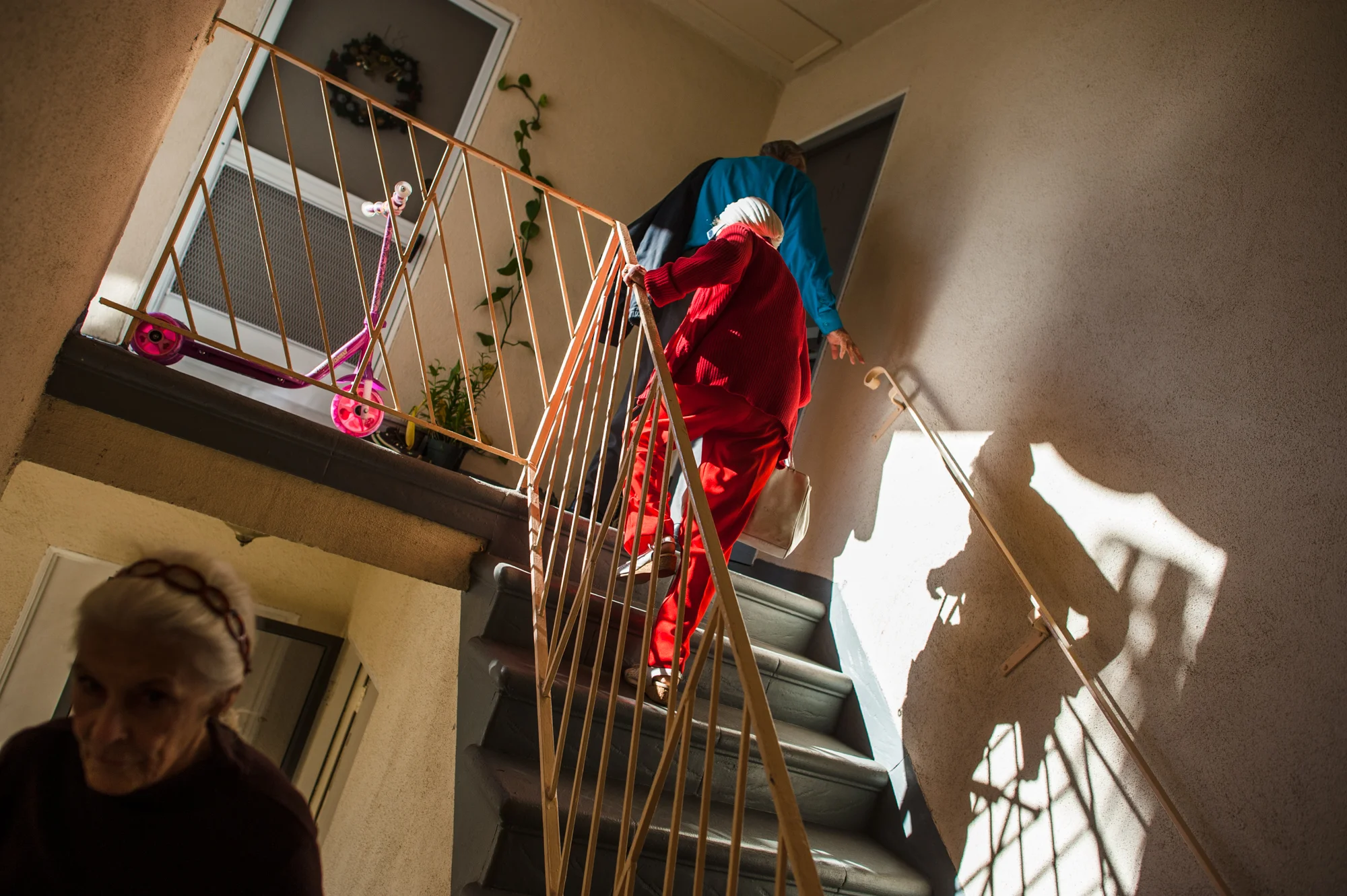 Adina, Will, and Jeanie climb a staircase to visit an apartment where they all may reside together.