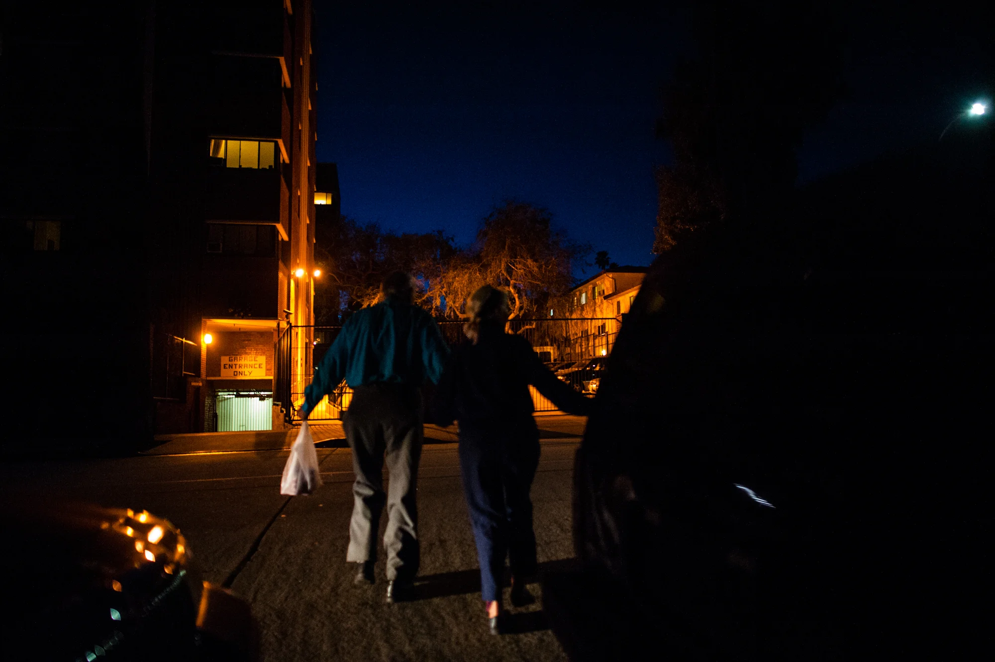 Jeanie and Will cross the street at night.