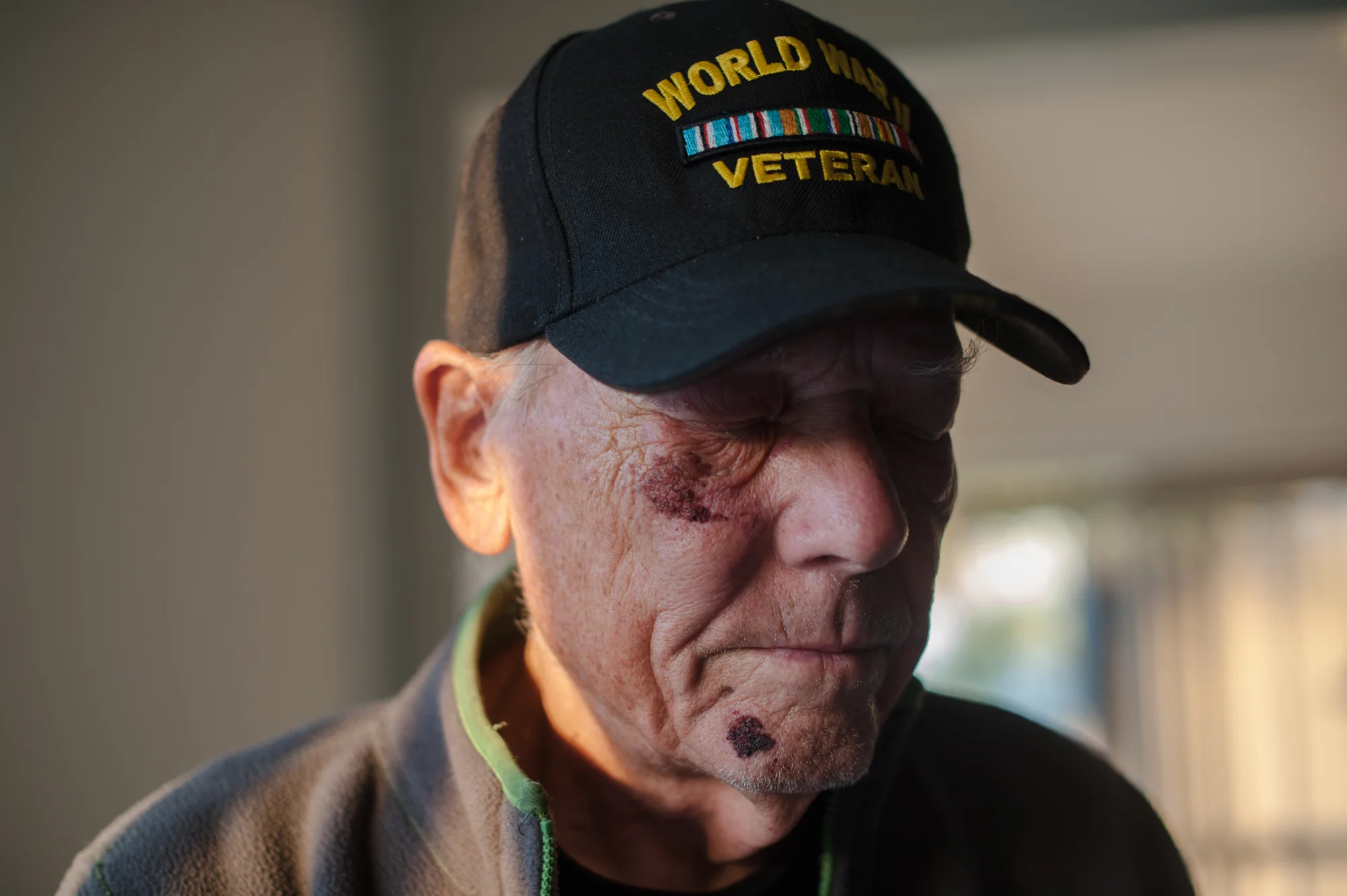 Will stands with his eyes closed, wearing his World War II Veteran cap.