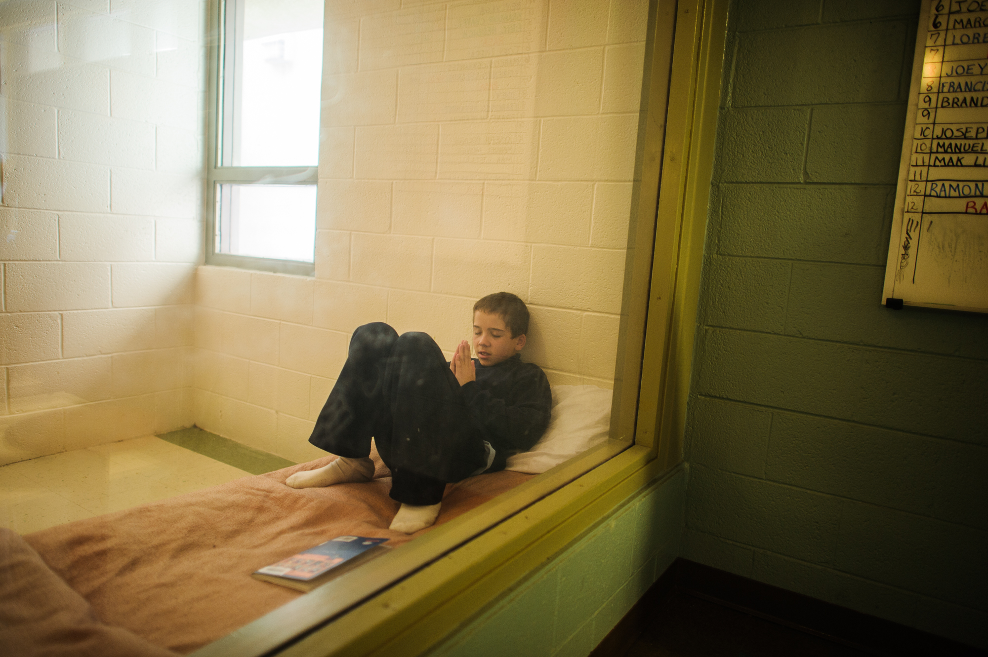  Vinny, age 13, prays inside his cell at the juvenile detention center, 2012. 
