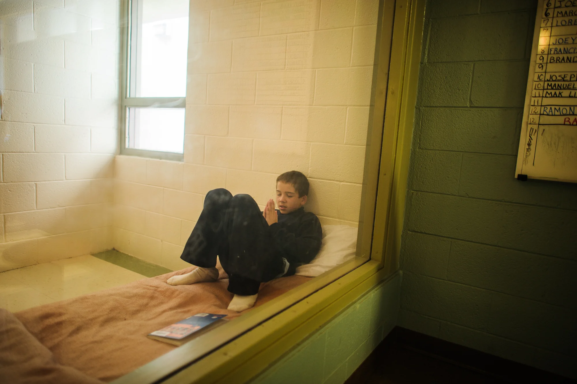 Vinny, age 13, prays inside his cell at the juvenile detention center, 2012.