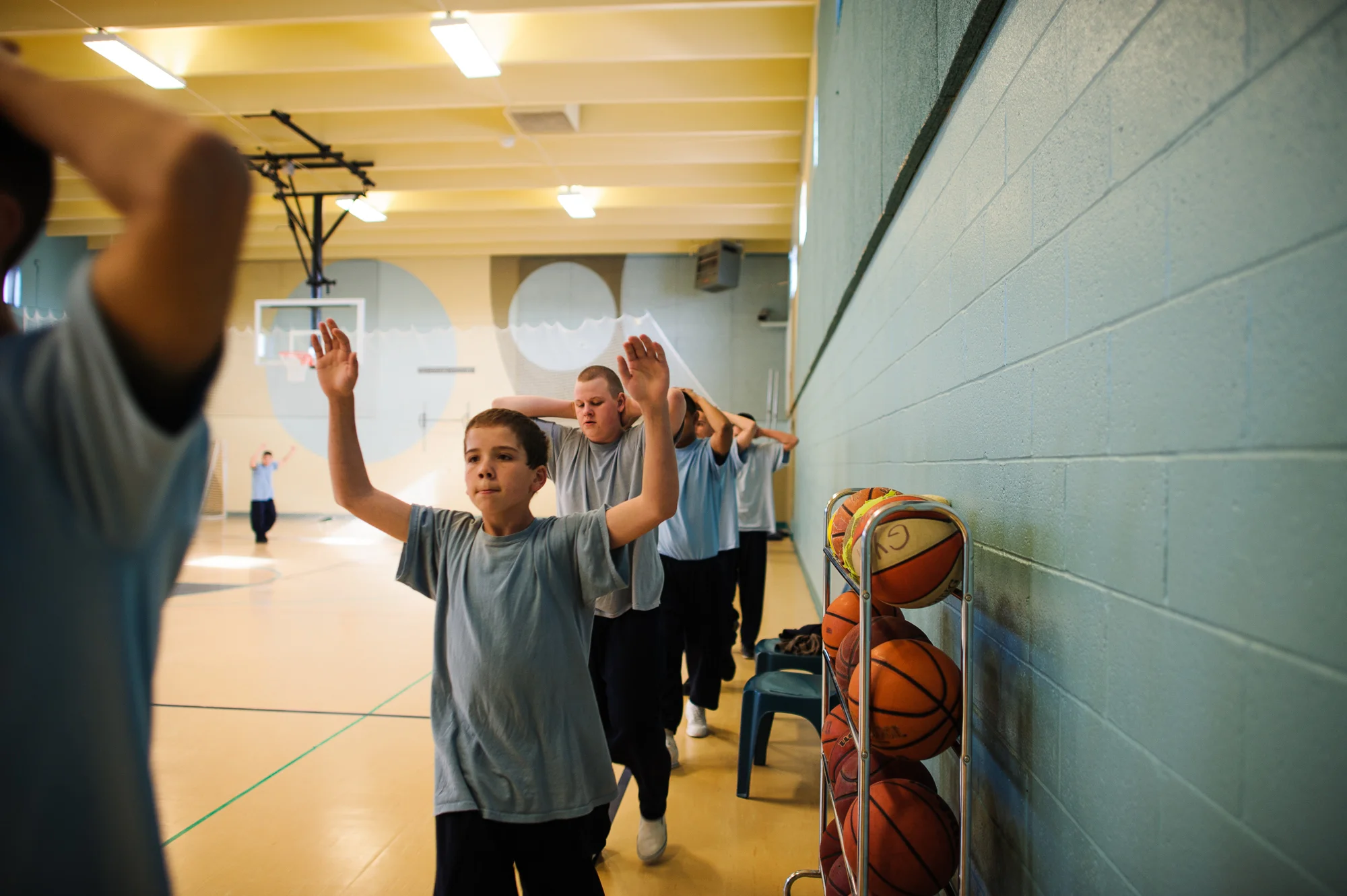 Vinny, age 13, walks with hands up as boys march in a circle inside the gym at the juvenile detention center, 2012.