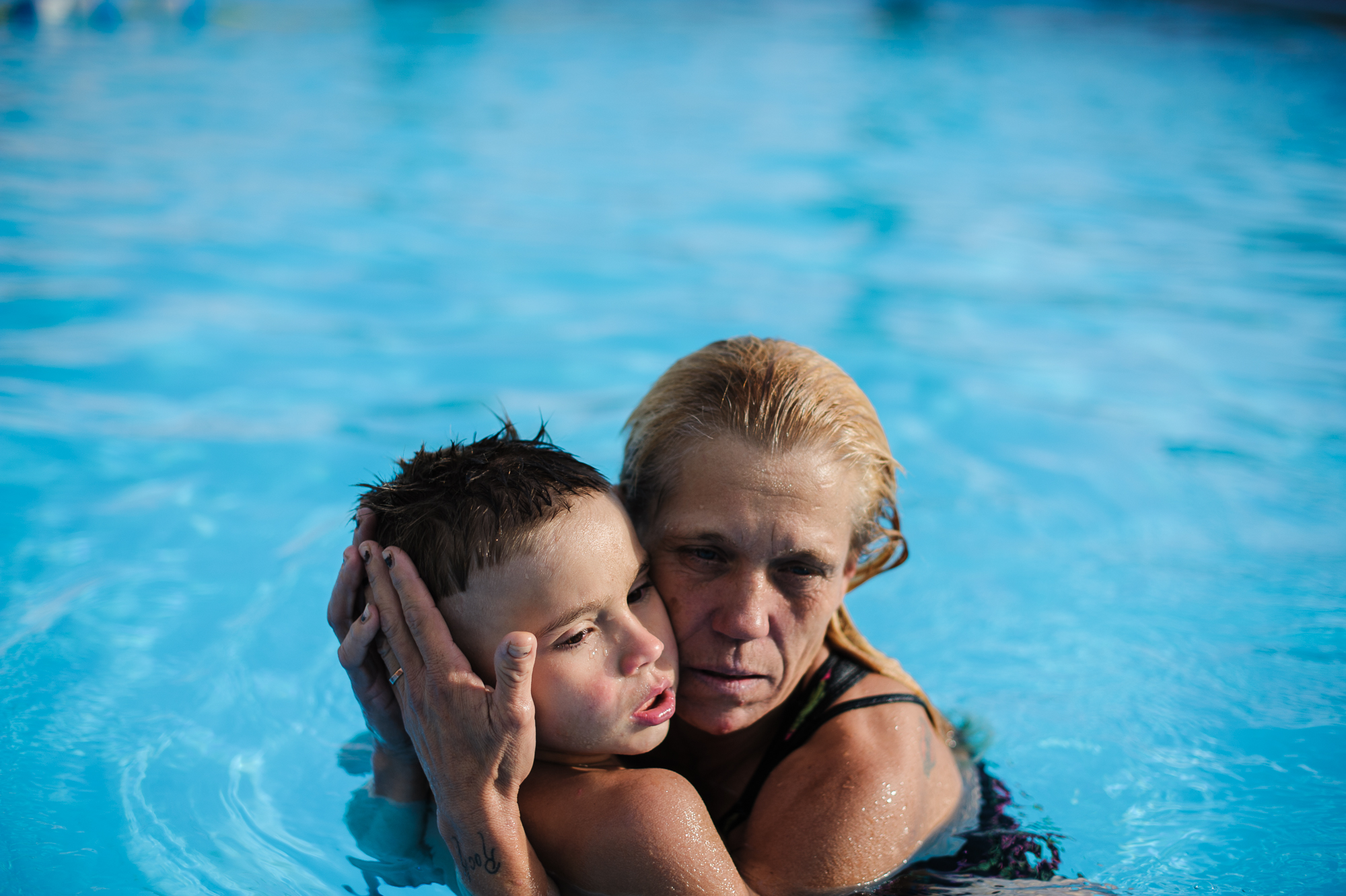  Eve holds her youngest son, Michael, in the pool at the motel, 2013. 