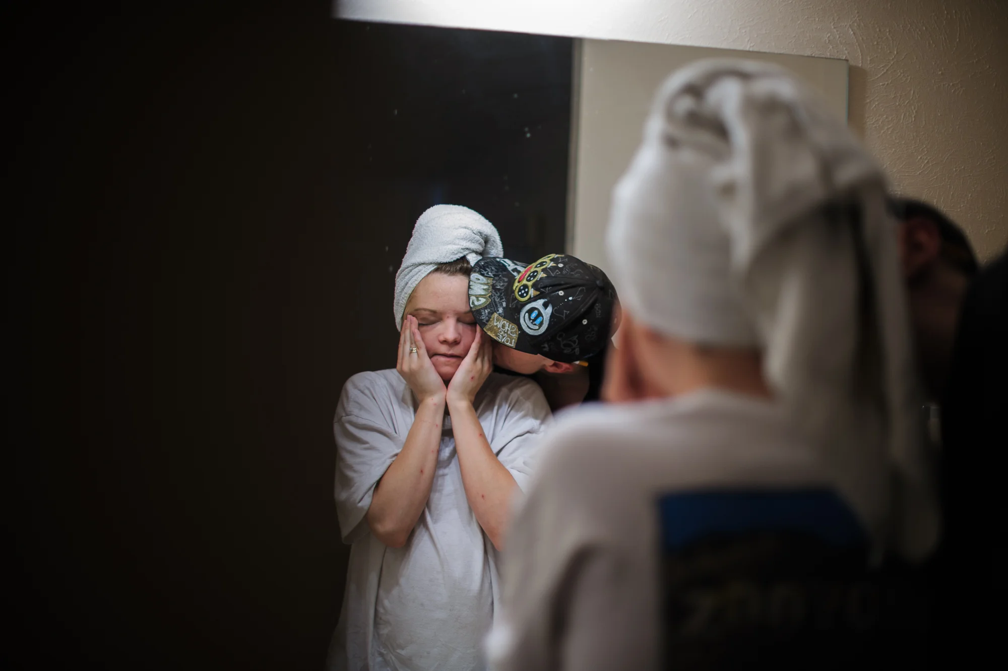 David, age 19, kisses Felicia, age 19, on the cheek in the motel room where they are residing, 2012.
