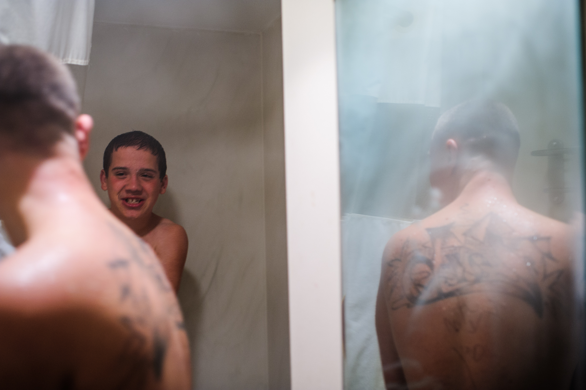  Vinny, age 15, and David, age 21, tease each other while Vinny showers, 2014. 