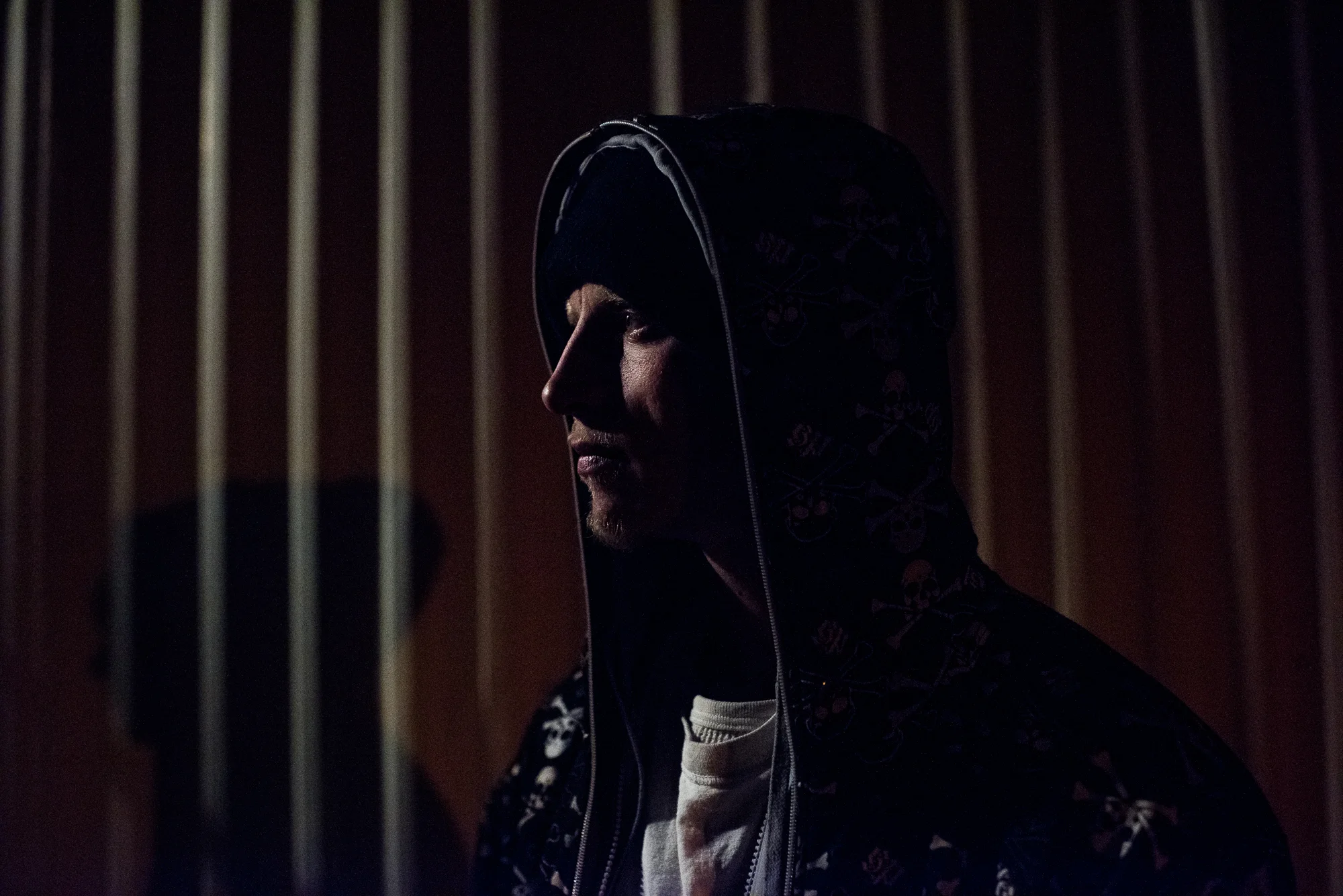 David, age 25, stands outside his mother’s trailer at night before going to sell drugs, 2018.