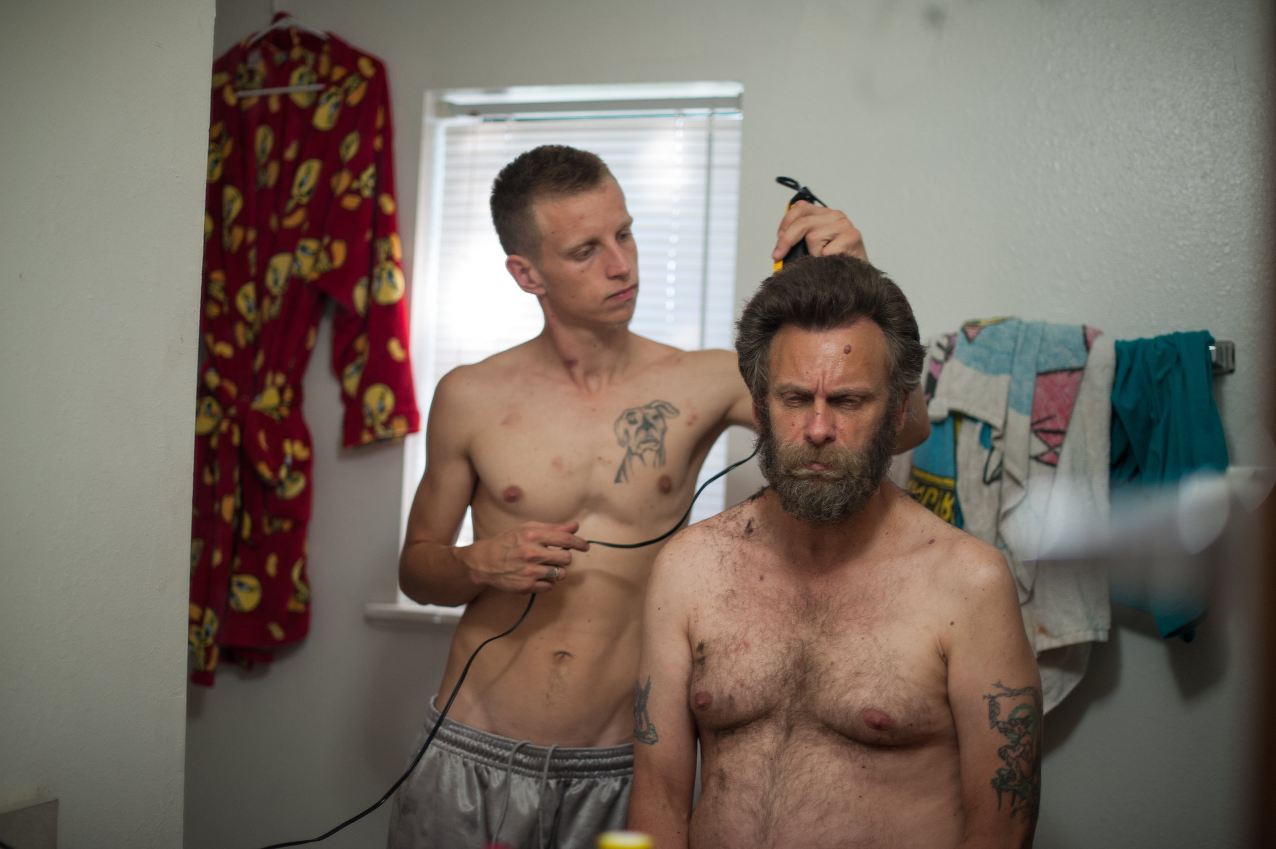  David, age 21, shaves his dad, Dave’s, head before David’s trial, 2014. 