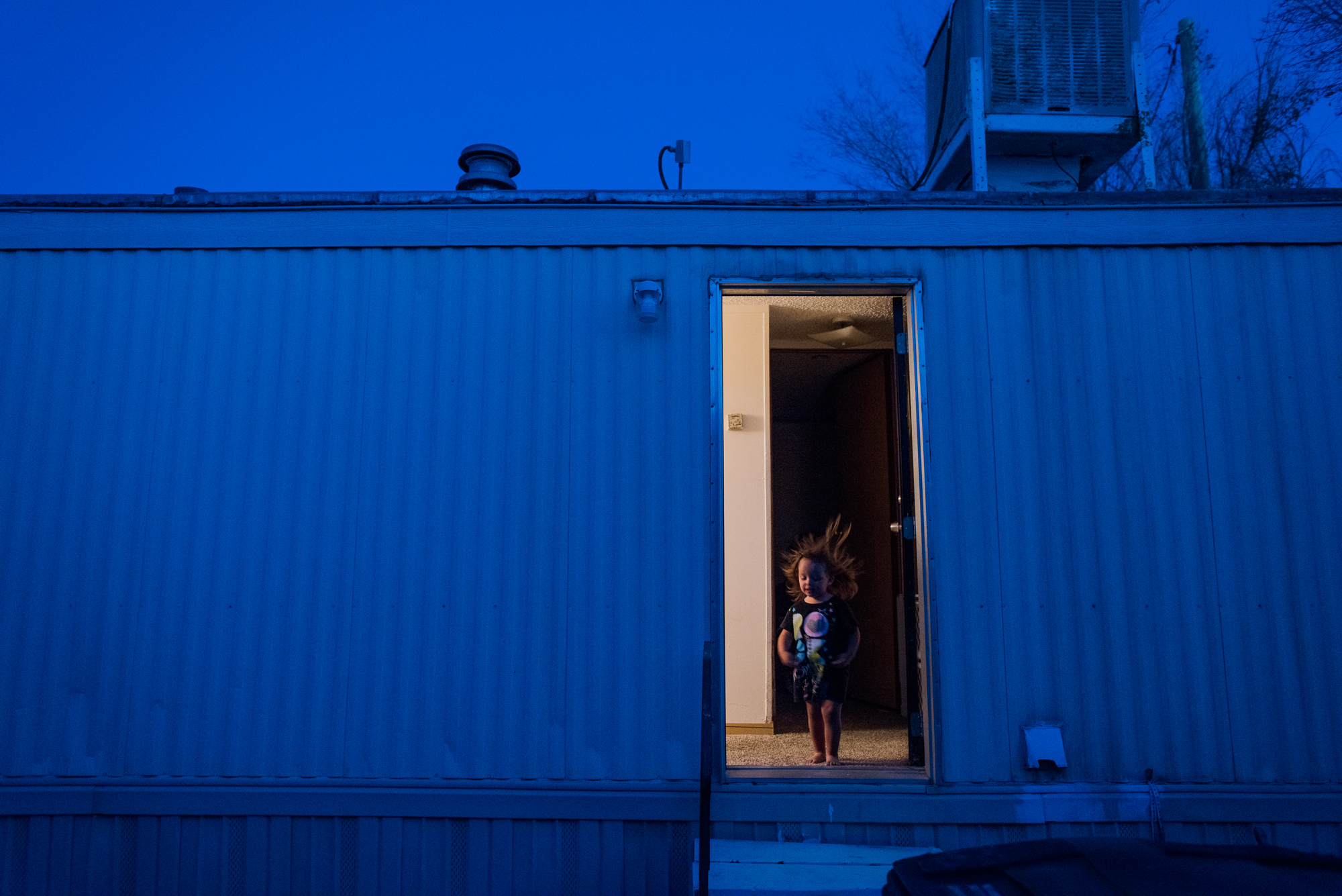  Jordyn, age 2, stands in the doorway of Eve’s trailer, 2018. 
