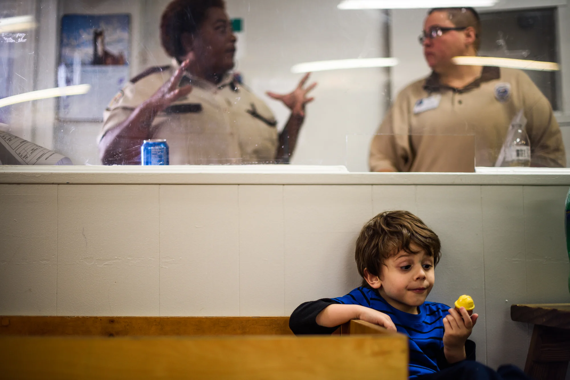 Angel, age 5, looks at a toy as correctional officers communicate behind him during a visit with his mother, Mary, at the Hernando Correctional Facility in Brooksville, Florida.