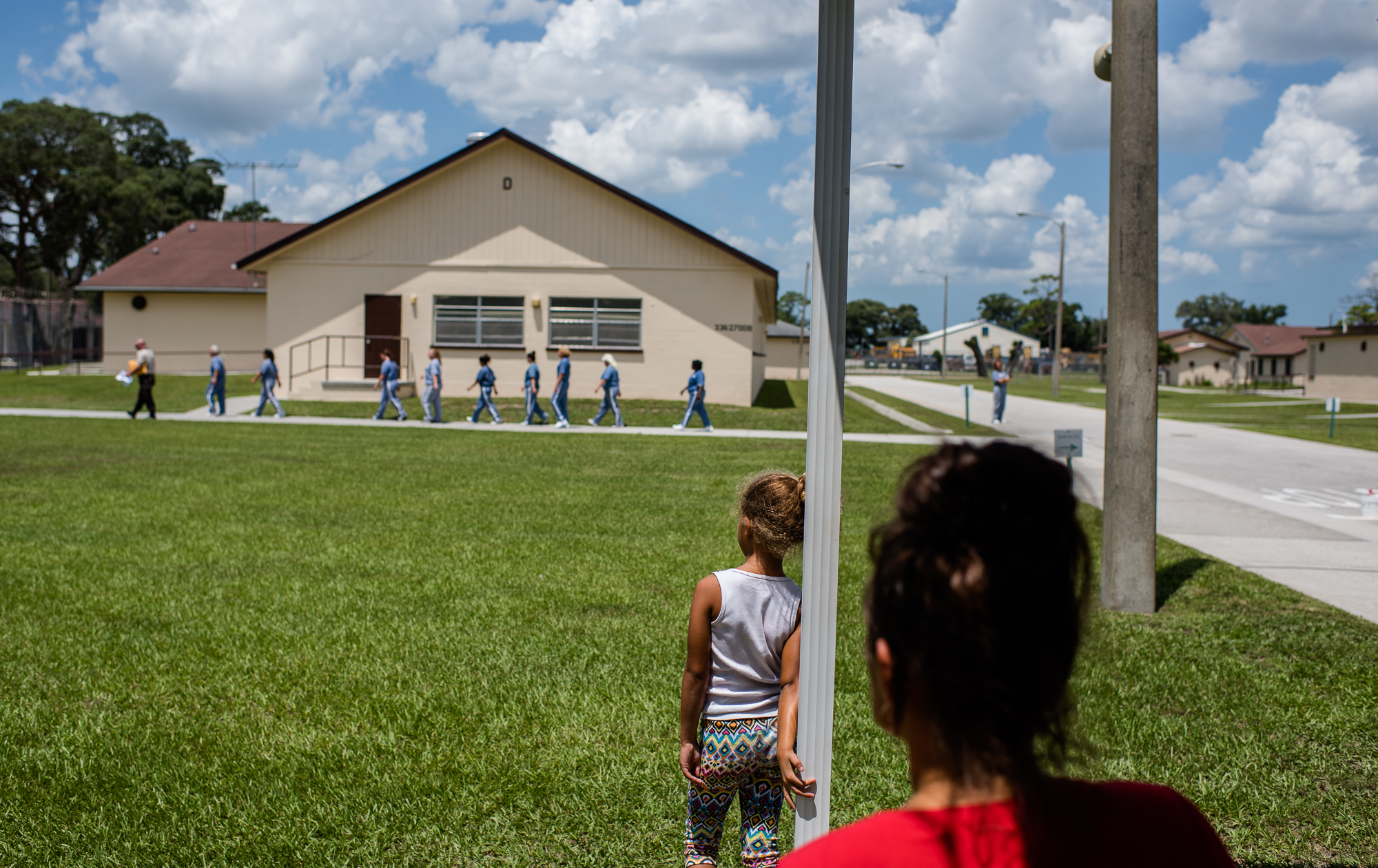  A girl watches a line of incarcerated women walk towards their housing unit at the Hernando Correctional Institution in Brooksville, Florida. 