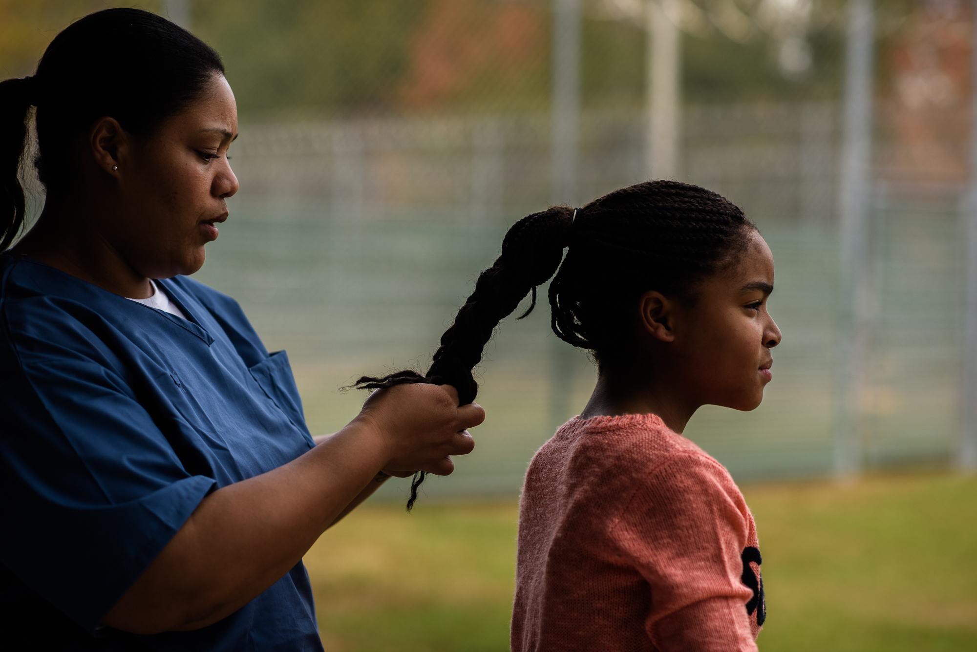  A mother braids her daughter’s hair in the recreation yard at the Lowell Correctional Institution in Ocala, Florida. 