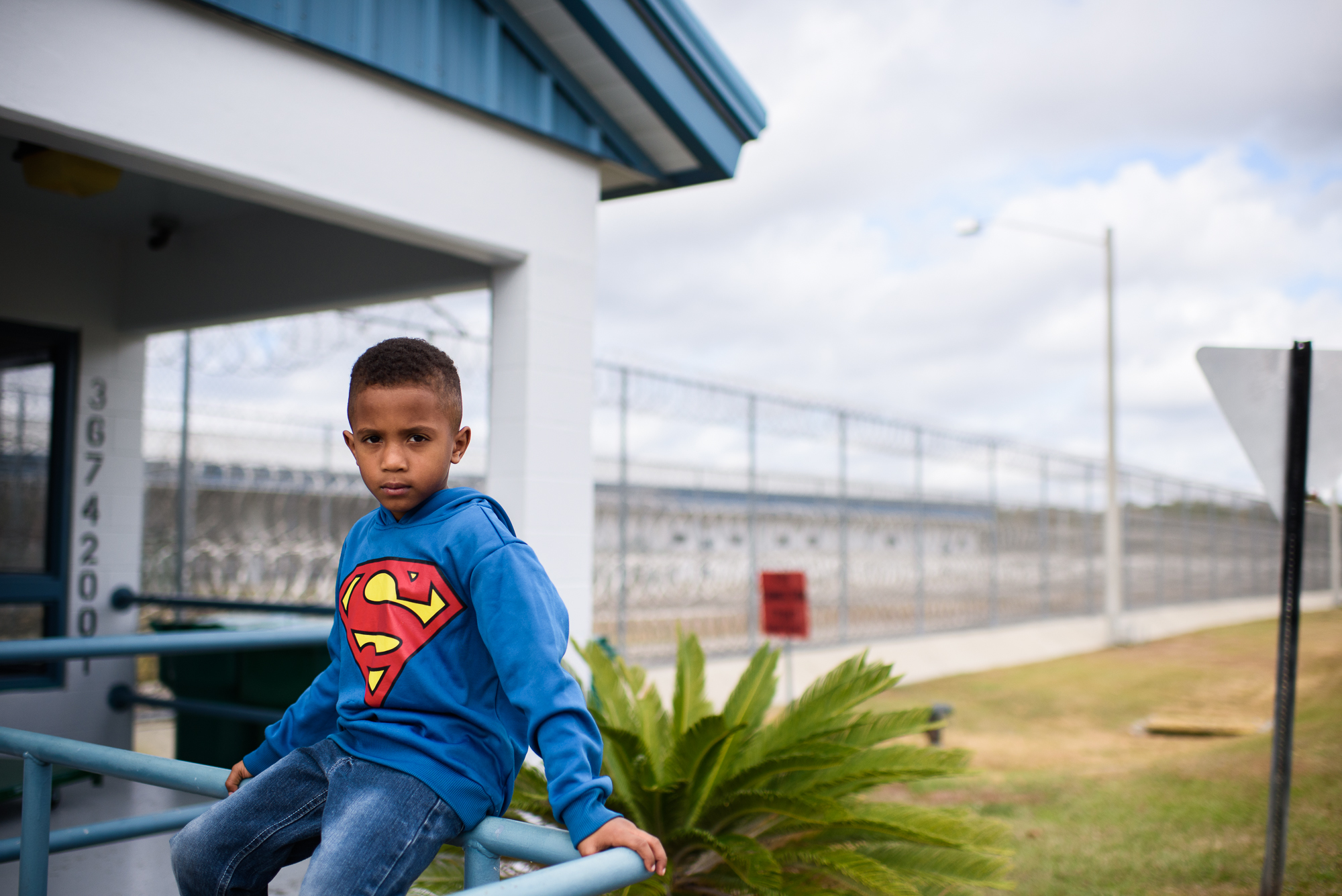  A boy sits outside the entrance of Lowell Correctional Institution in Ocala, Florida before visiting his mom. 