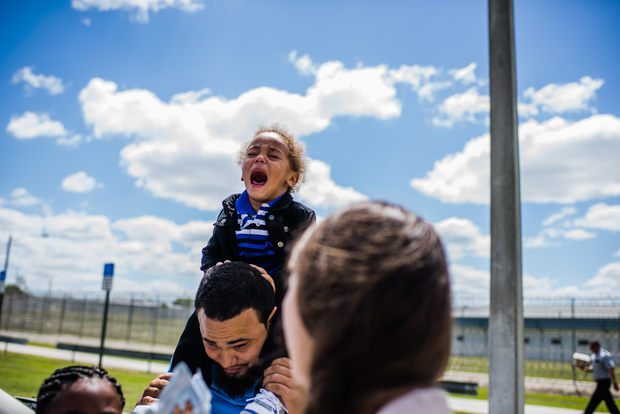  A boy cries while sitting on his father’s shoulders upon exiting the Lowell Correctional Institution in Ocala, Florida, where his mom is incarcerated. 