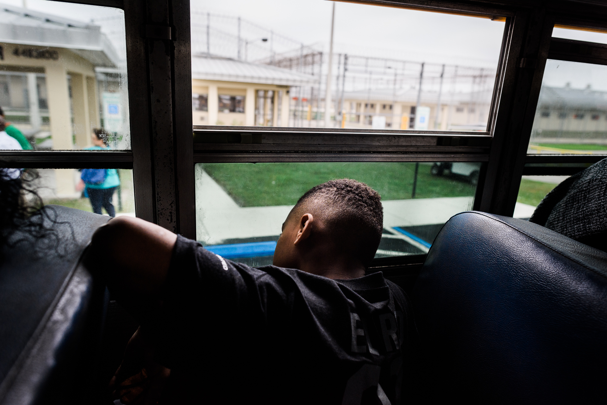  Rodarian, age 9, sits on the bus after seeing his father at the Everglades Reentry Center in Miami, Florida. 