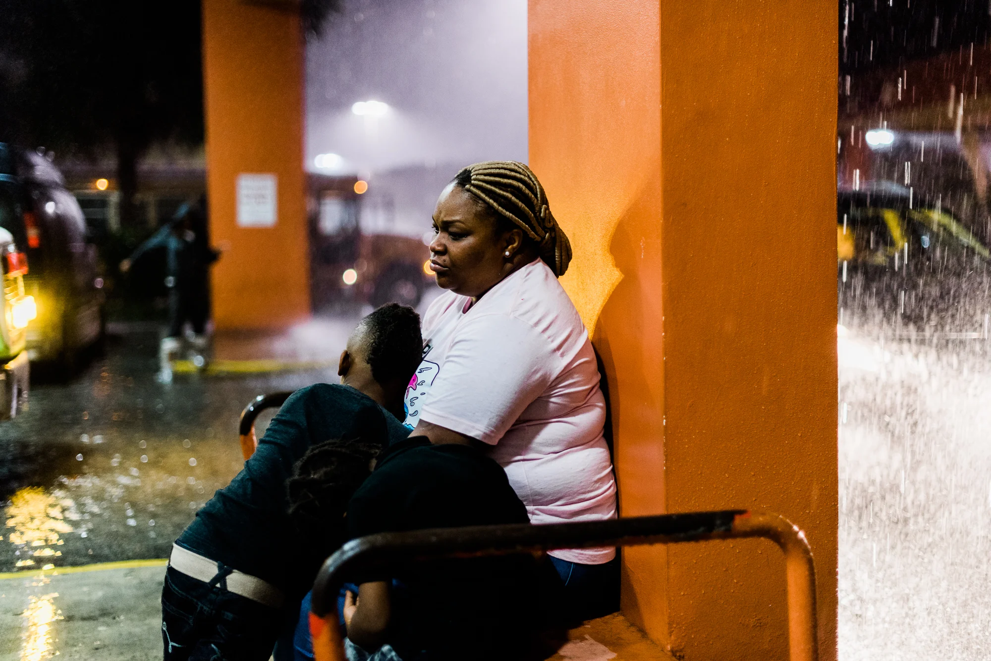 Rohondrick, age 6, and Romarion, age 4, lean against their mother, Sandrika, outside an ice skating rink after their visit with their father at the Everglades Reentry Center in Miami, Florida. The organization that provides these visits bring the children to another location after the carceral experience in order for them to have a calming effect before returning home. Rogelio, their father, is incarcerated for 3 years for being in possession of a handgun by a felon. Rogelio was incarcerated at the age of 18 for drug possession. After release, he got sober and worked as a chef in a Cuban restaurant. At the age of 41, he was driving to work when police pulled him over and found a handgun registered to his cousin in Rogelio’s vehicle. Rogelio says that he did not know that the gun was left in his car. Sandrika, who now works as a manager at an Einstein Bagels, and is the sole provider for her family, says of Rogelio, “He was a very hands-on father. Very active. He’s a family man. He loves his family. I was spoiled. He used to iron their clothes, dress them, take them to school, to football practice. Now he can only call to wake them up every morning.” She continues, “I try to give them a normal life even though their dad is in prison.”