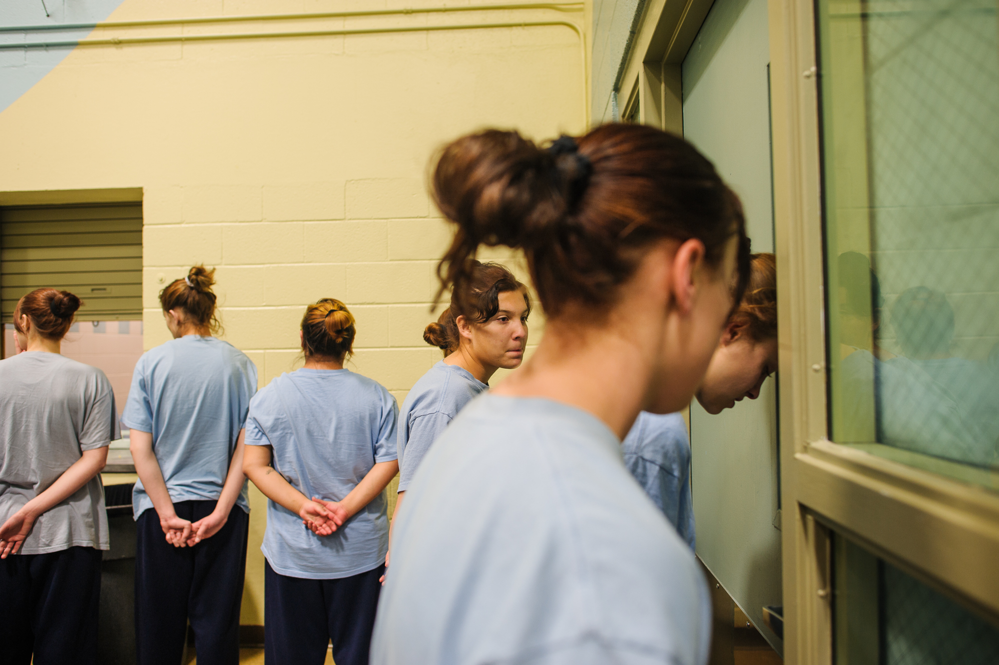  Alysia, age 16, leans her head against a door as she stands in line with other girls in the cafeteria of the juvenile detention center in Albuquerque, NM. 