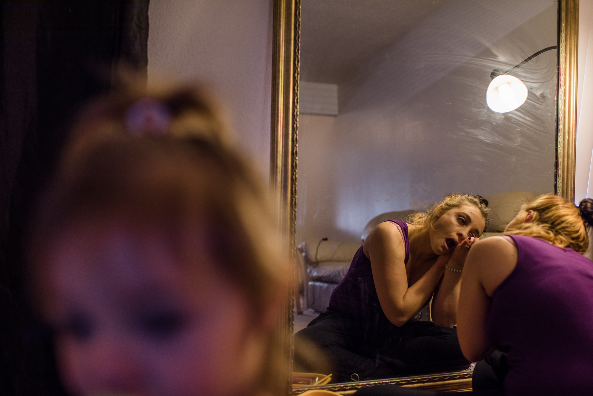  Alysia, age 20, puts on makeup in the morning, as her daughter, Leticia, stands beside her.  