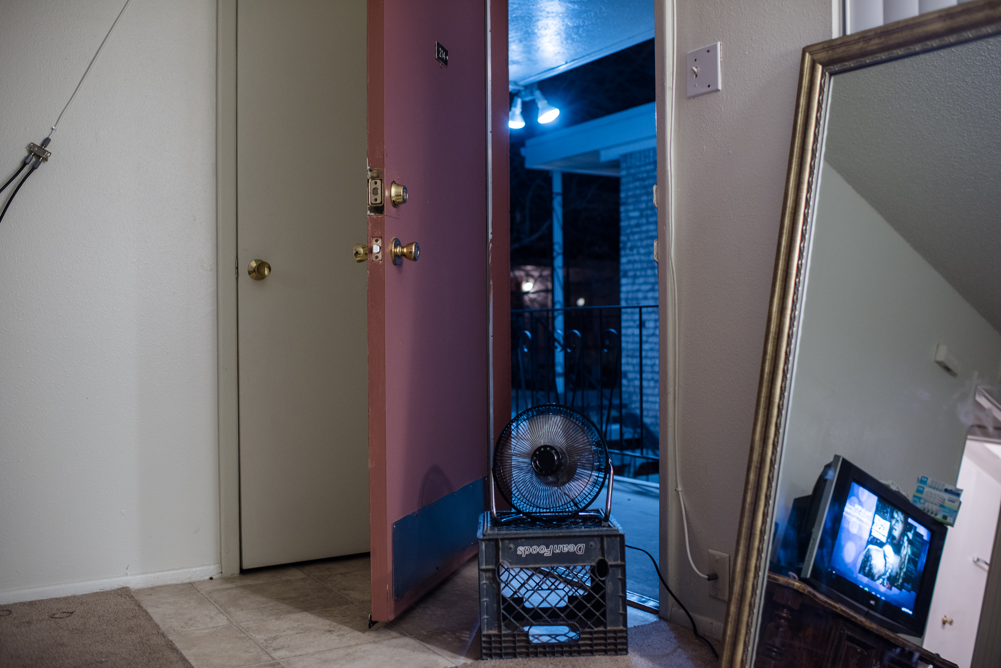  A fan and open door on a summer day at Alysia’s apartment,  