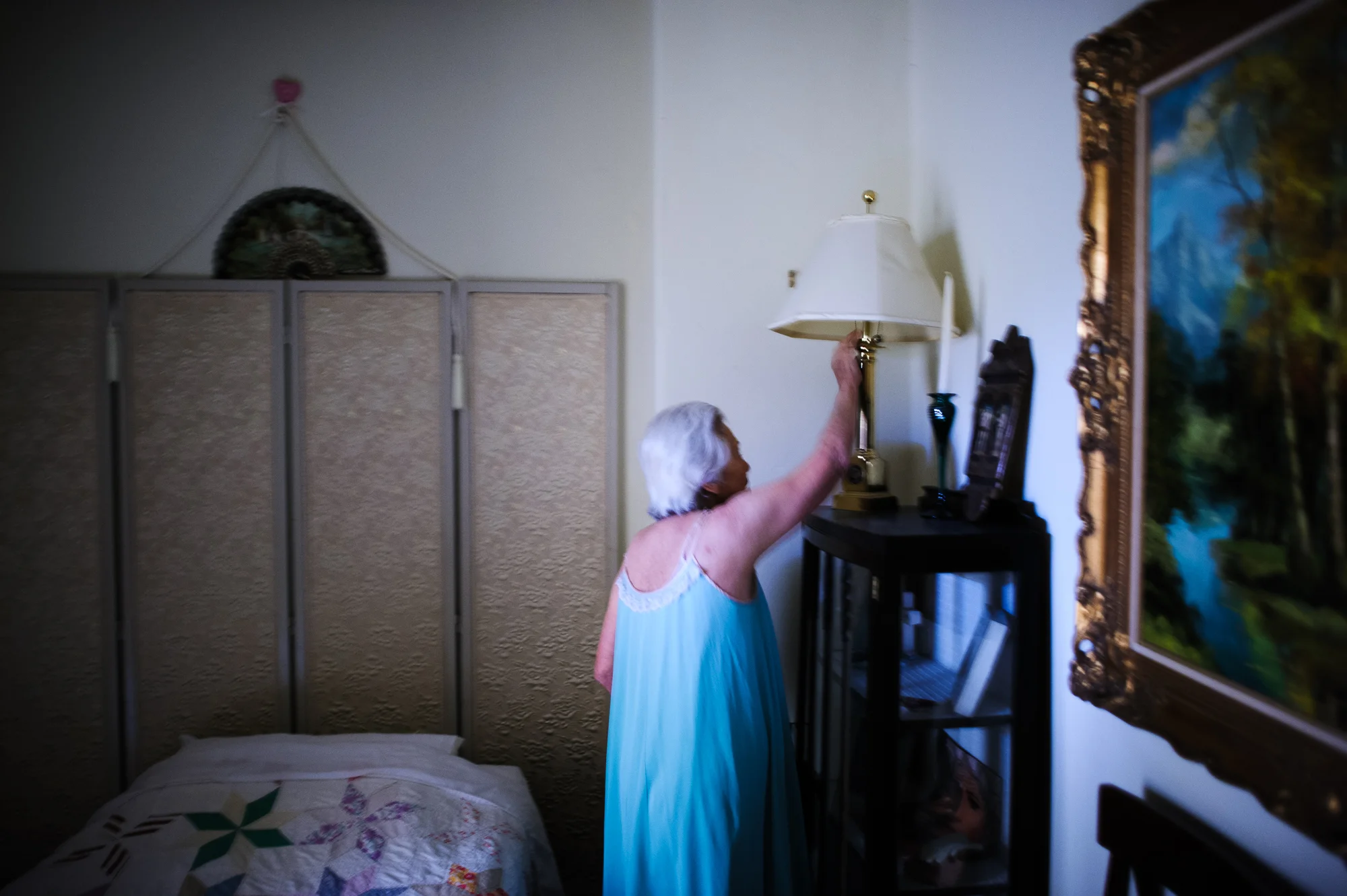 Bianca, age 84, turns on the light in her apartment at the retirement home at night, 2009.