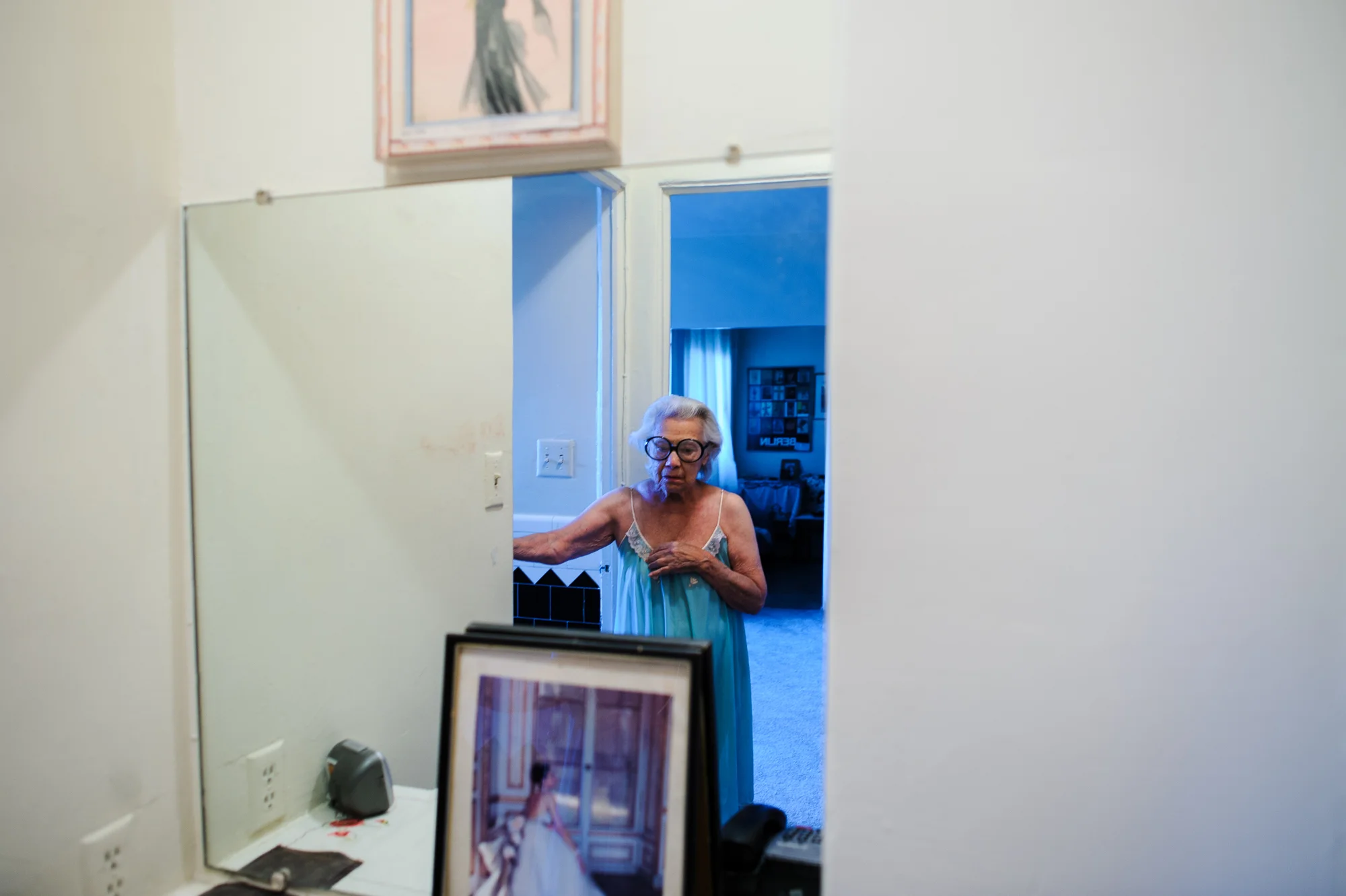 Bianca, age 85, wears her signature glasses and nightgown in front of her mirror, 2010.