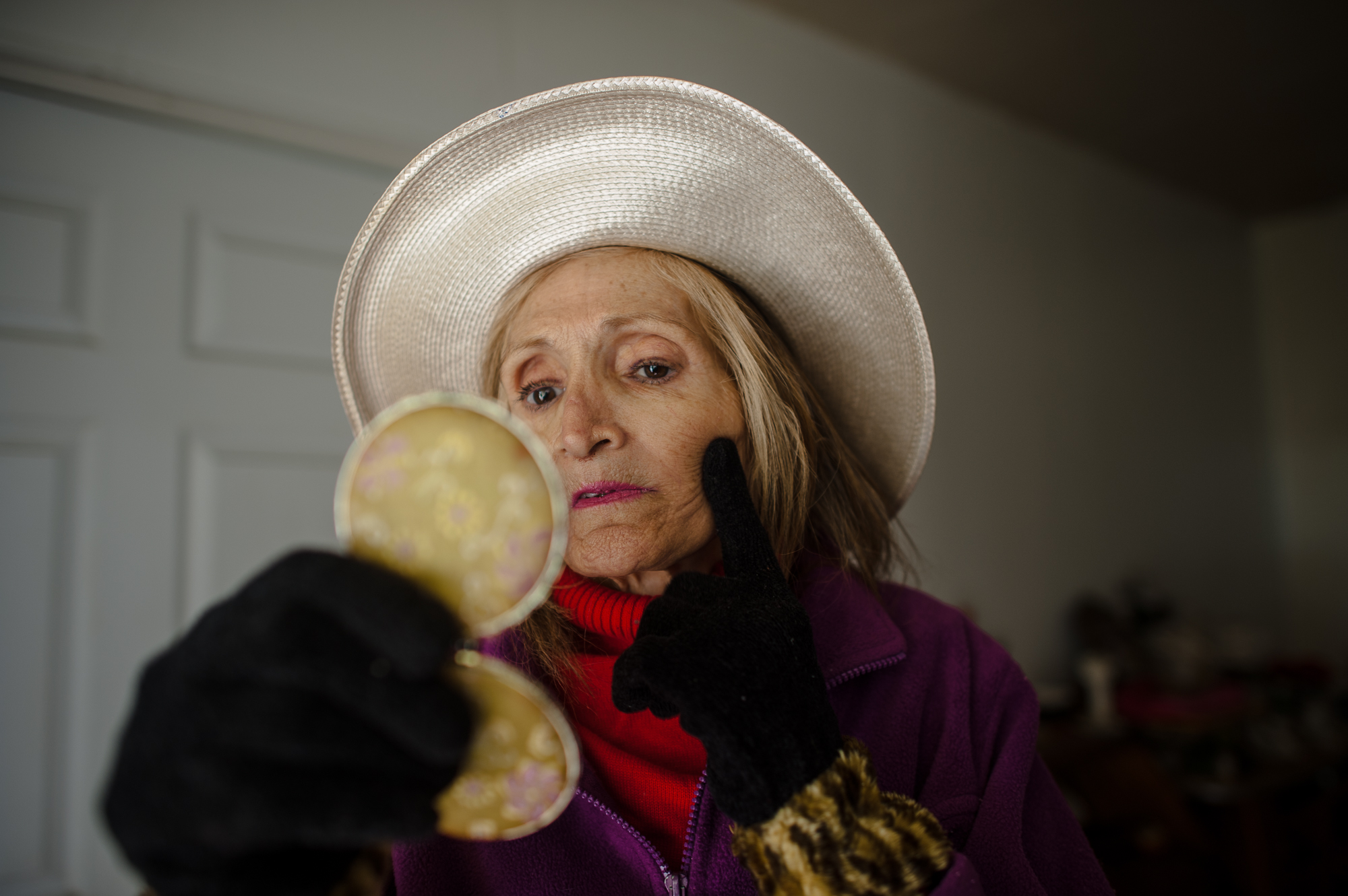 Rosie checks her face in a compact mirror before going to the supermarket.