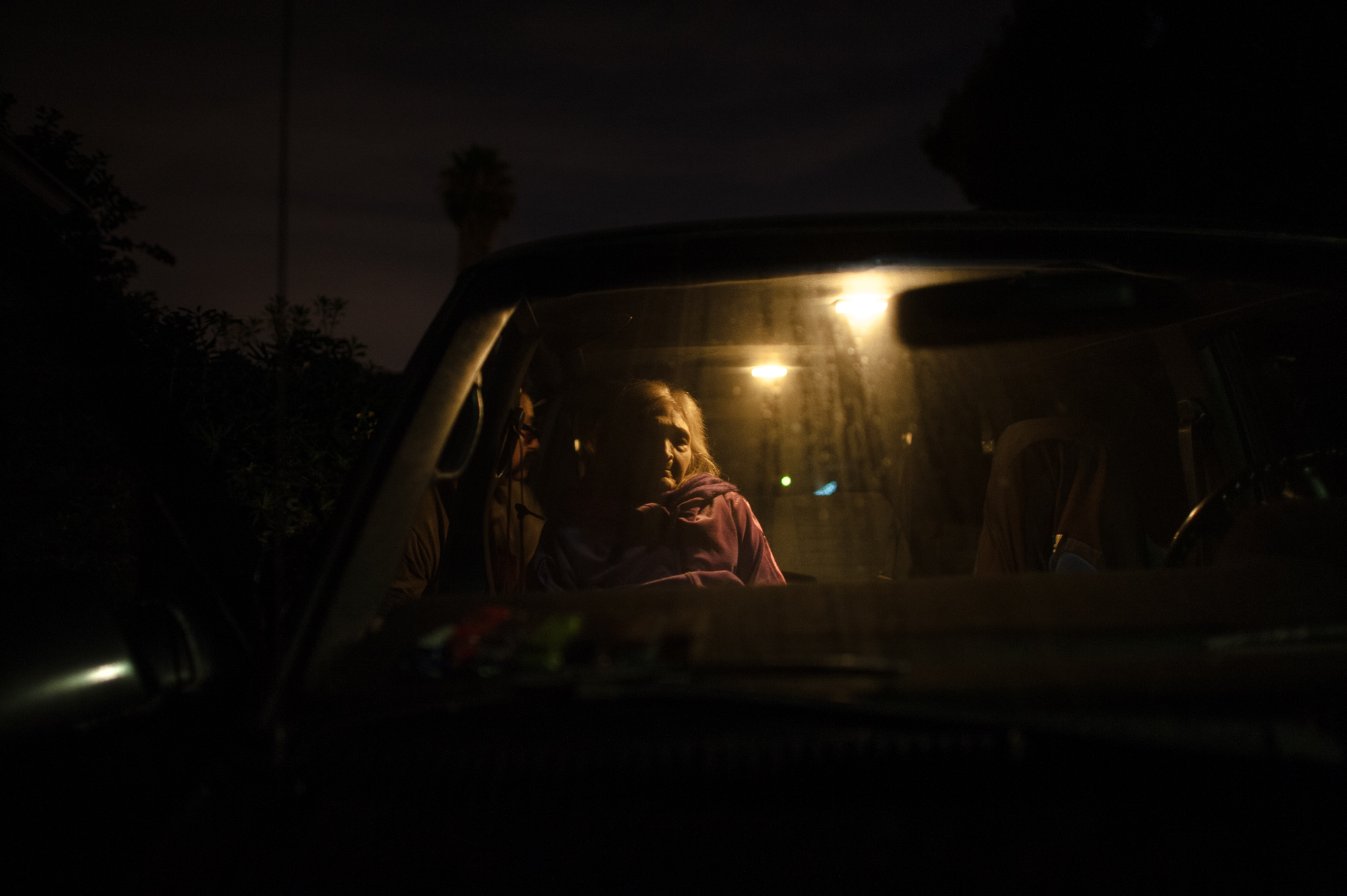  Rosie sits in the van at night, as Adam puts away her walker.  