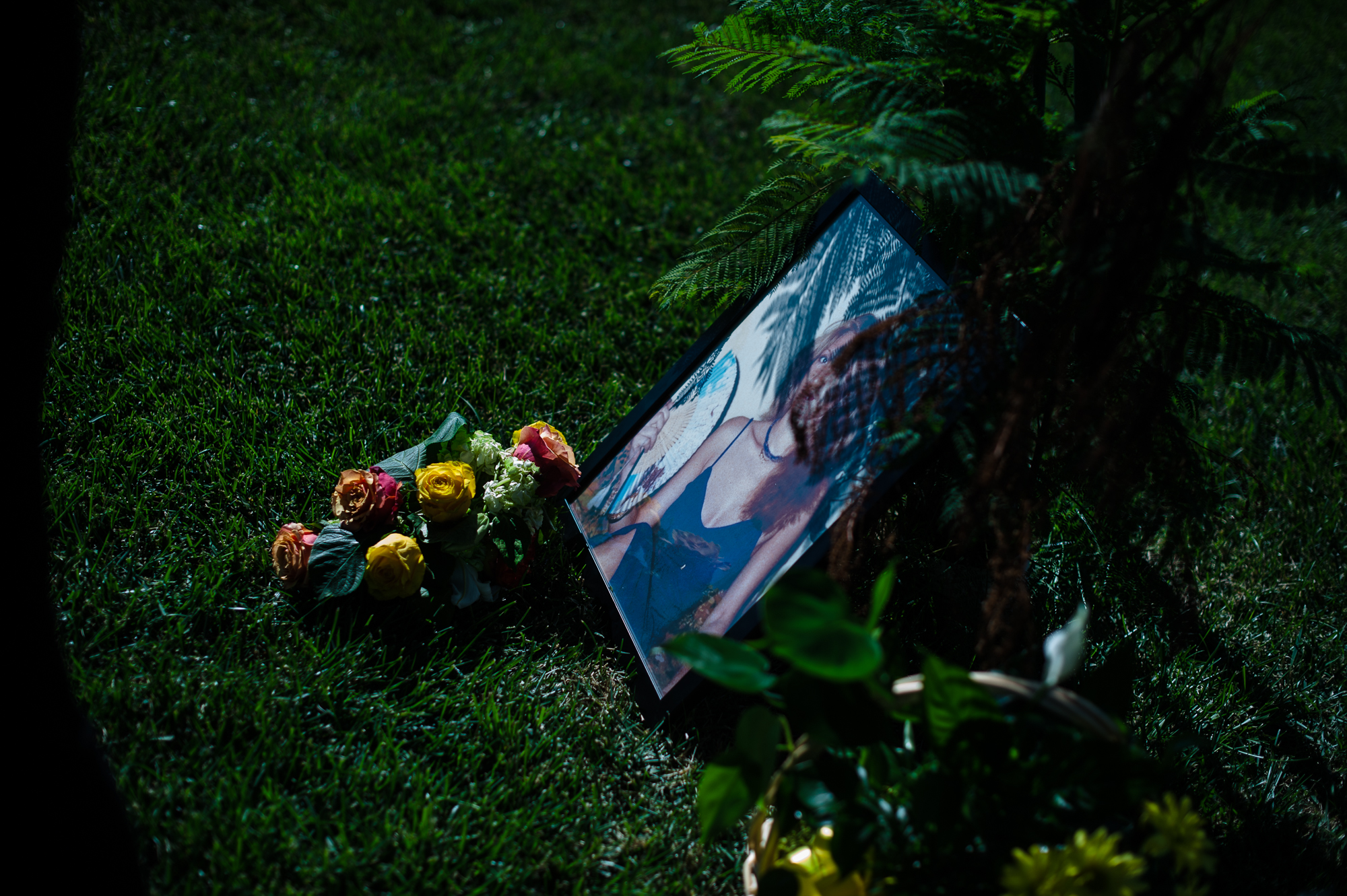  A portrait of Rosie and some flowers next to her grave at her funeral.  