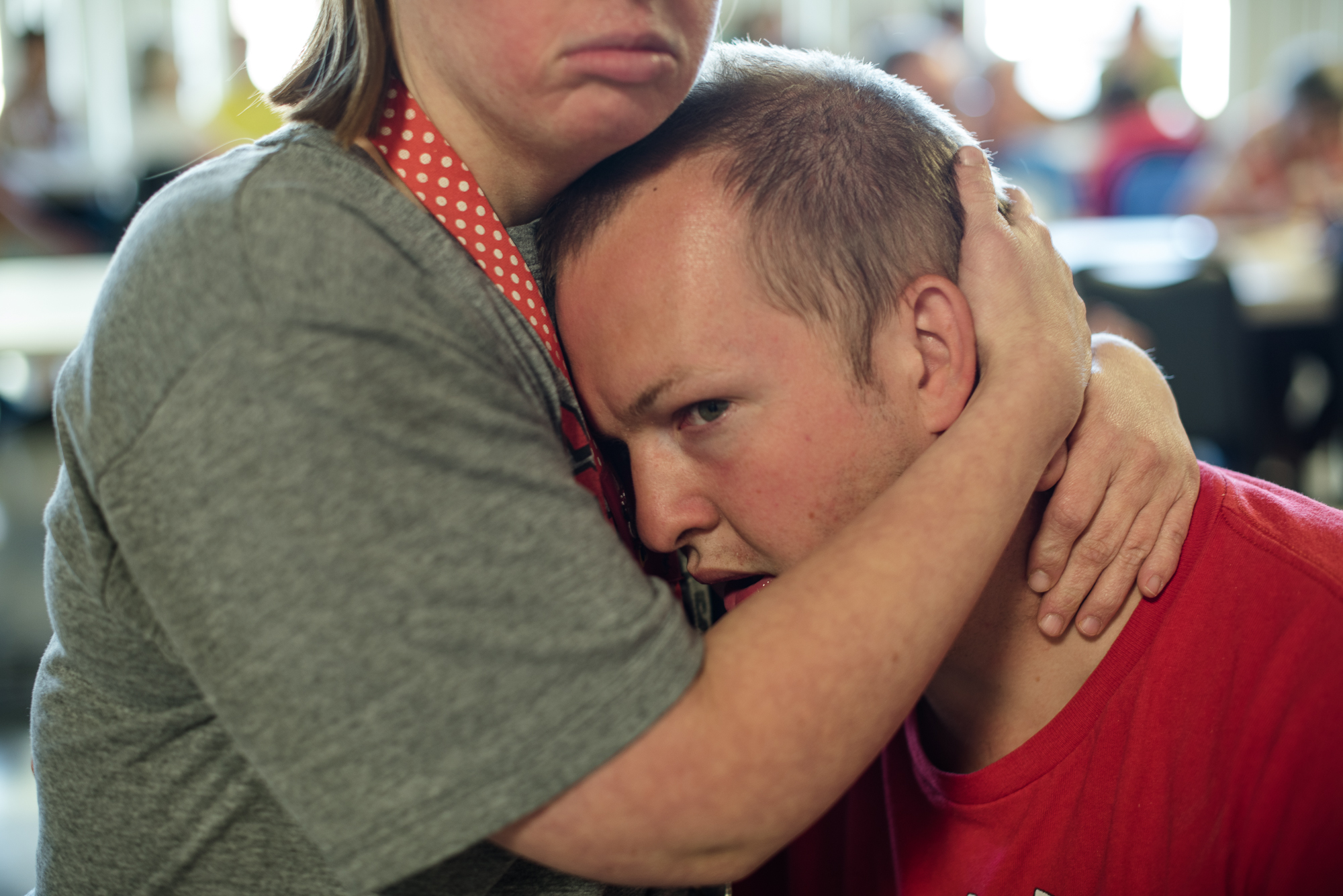Krysta holds Nathaniel’s head to calm him down as he experiences frustration towards the behavior of other residents.
