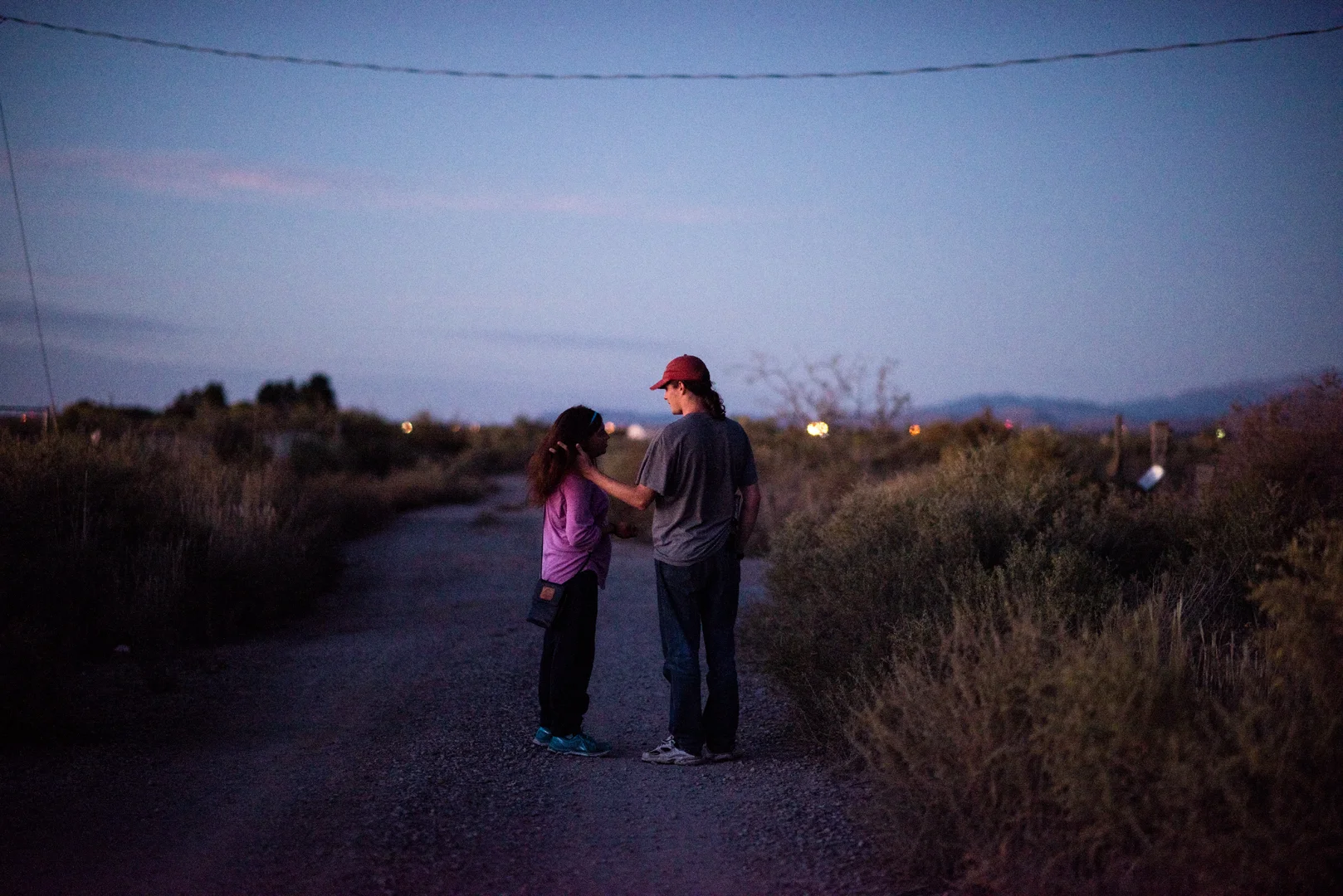 Delilah and Alex stand on a dirt road near his grandfather’s property.